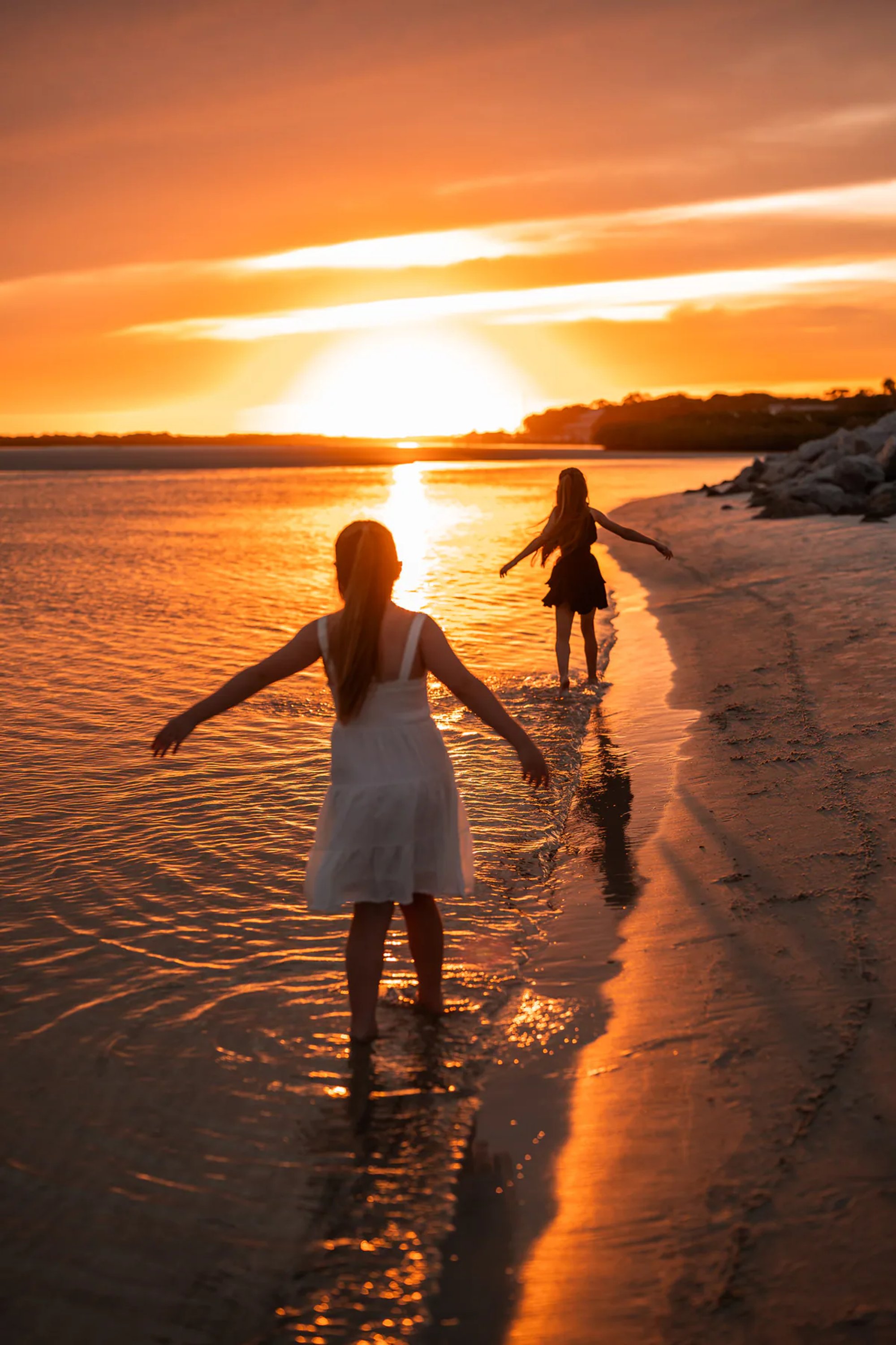 Child standing in shallow water during a sunset beach family photography session in Ponce Inlet.