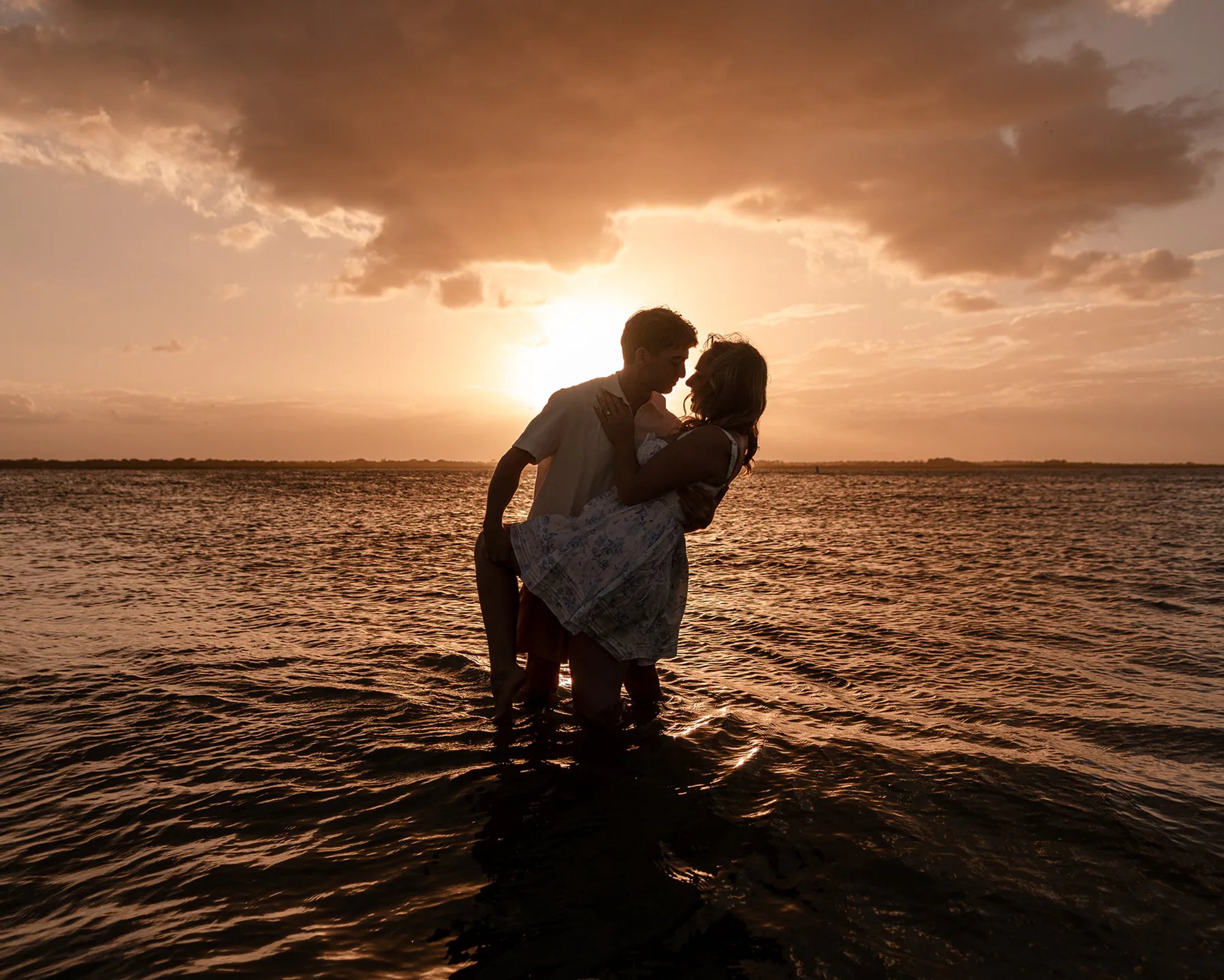 New Smyrna Beach engagement portraits at sunset, Joey and Lexi sharing a quiet moment by the water.