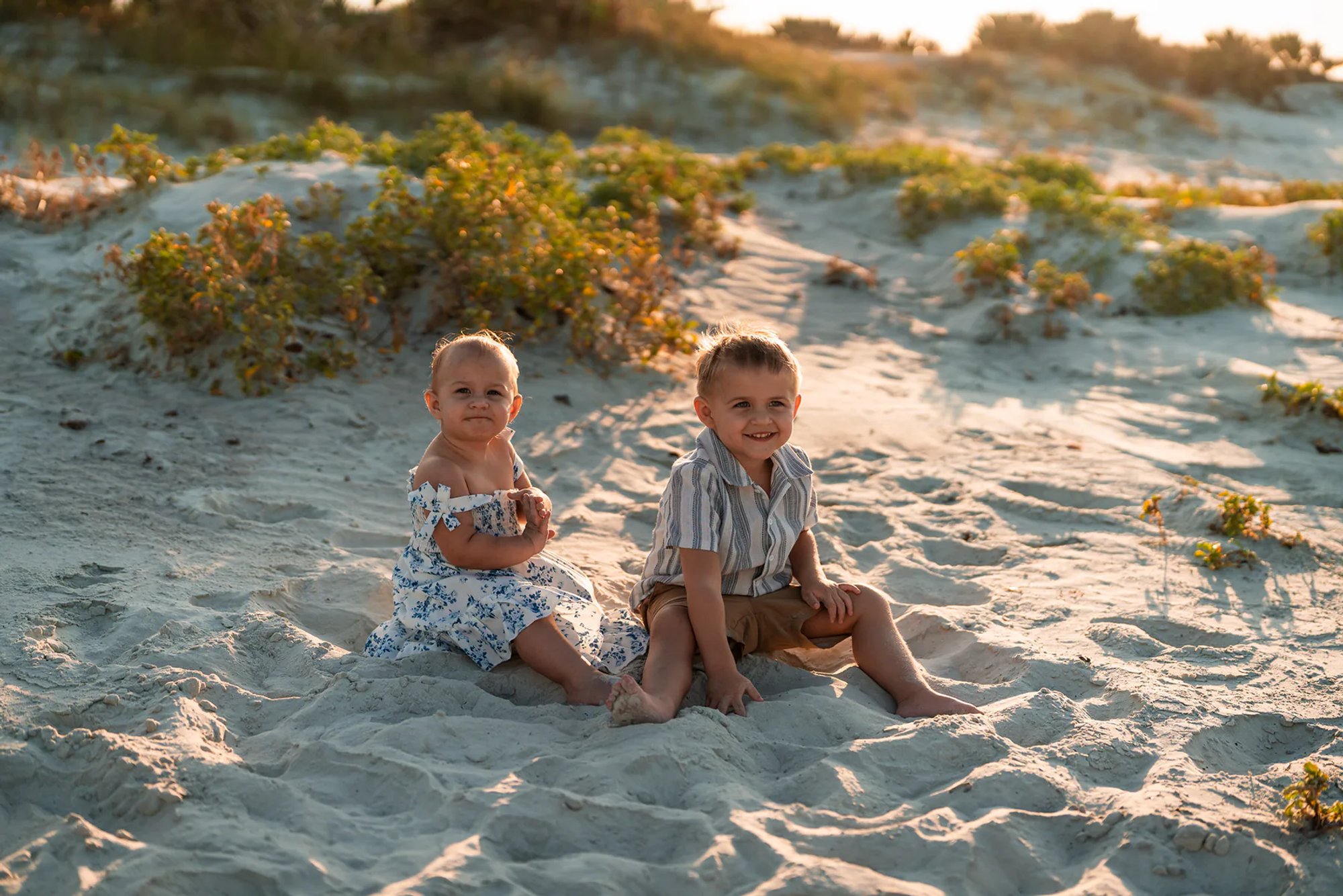 Two children sitting in the sand during a Ponce Inlet beach family photo session