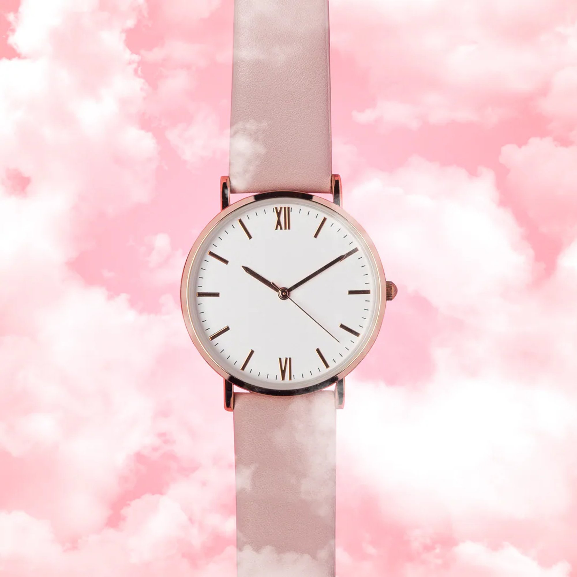 Minimalist wristwatch centered over a pink cloud background.