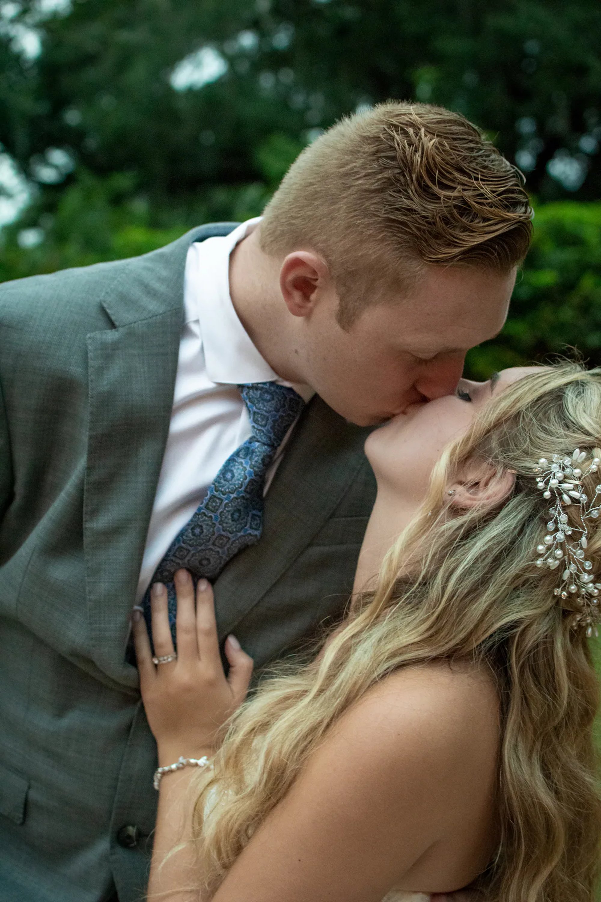 Groom kissing the bride during a close outdoor wedding portrait.