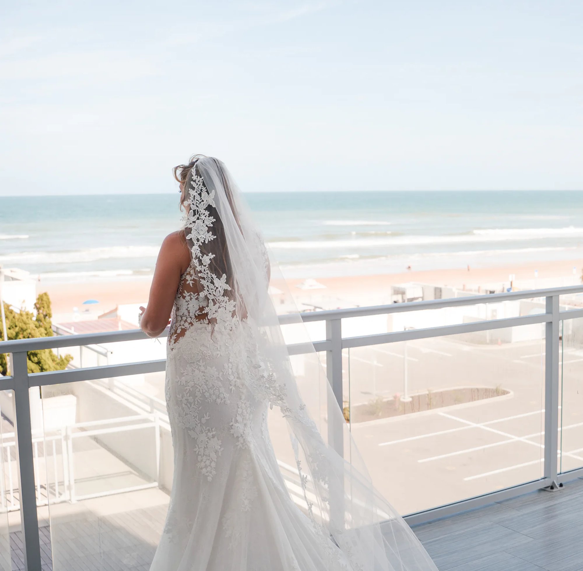 Bride overlooking the ocean from a balcony at Hard Rock Hotel in Daytona Beach, FL.