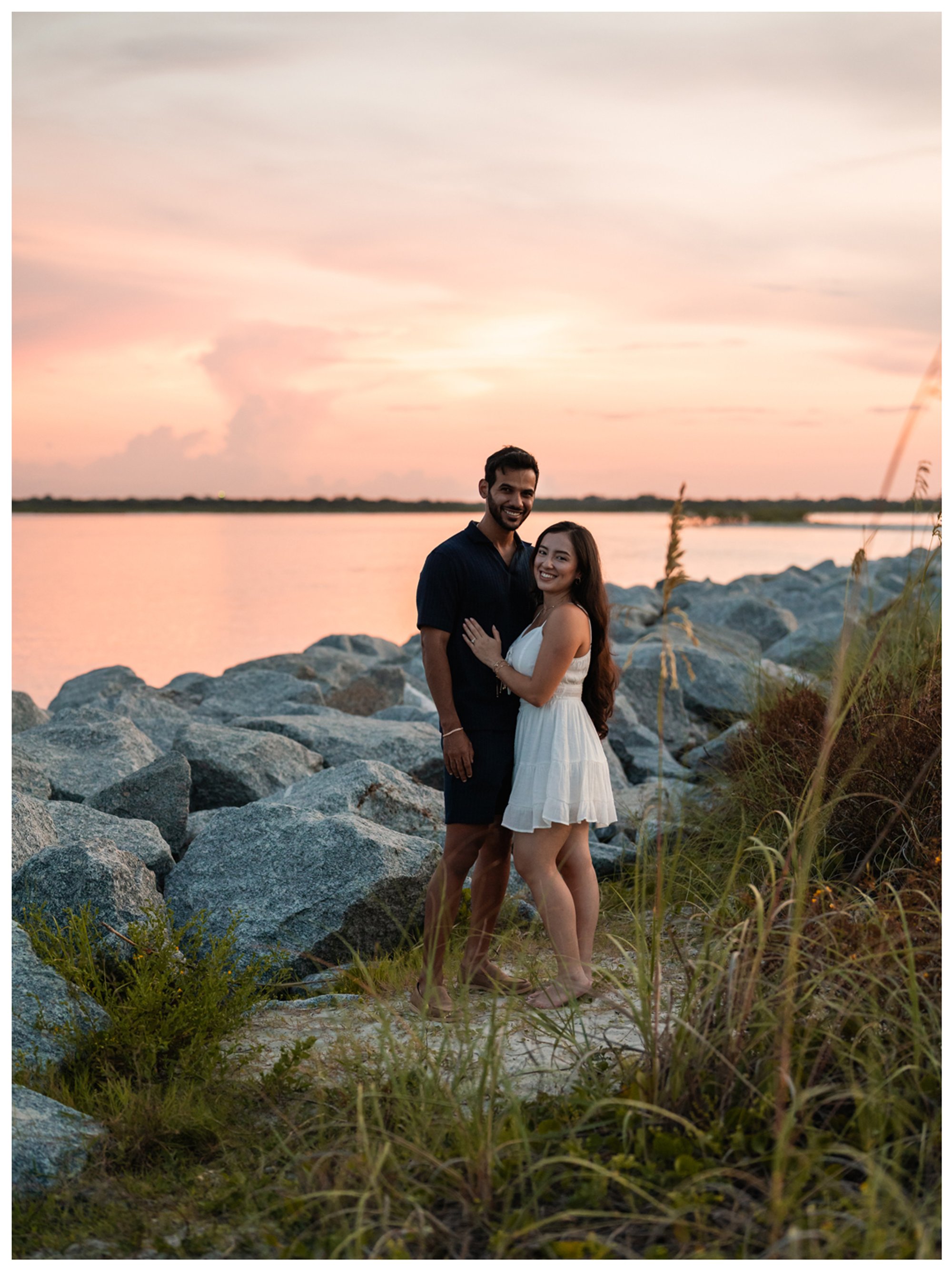 Vertical sunset portrait of Dierick and Paulina beside the rocks at Ponce Inlet.