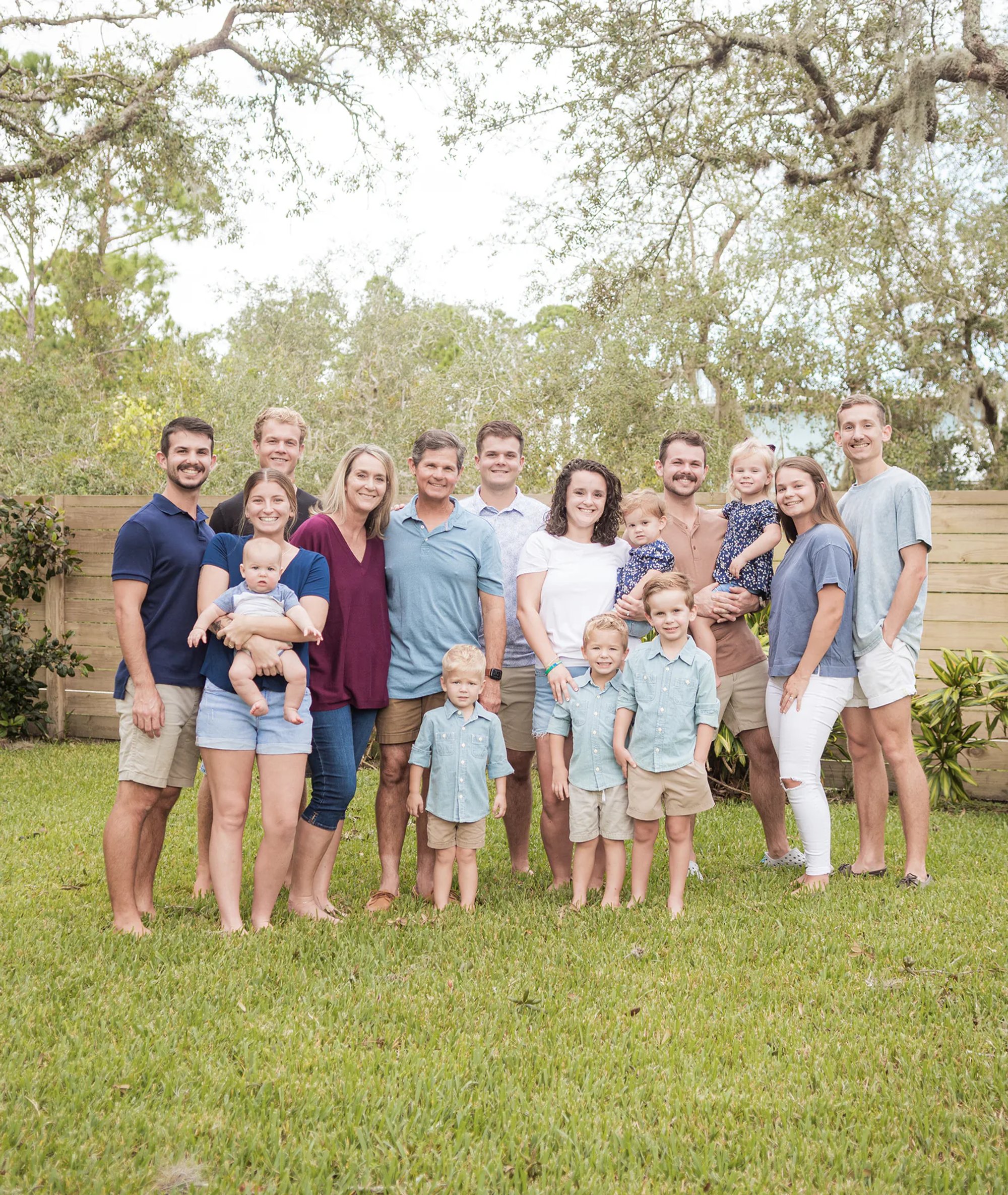 Large extended family posing together on a grassy lawn.