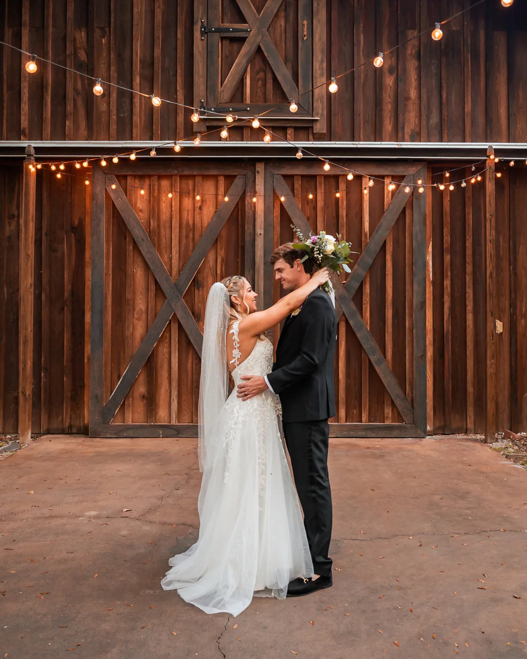 Bride and groom first dance inside rustic barn wedding venue in DeLand Florida
