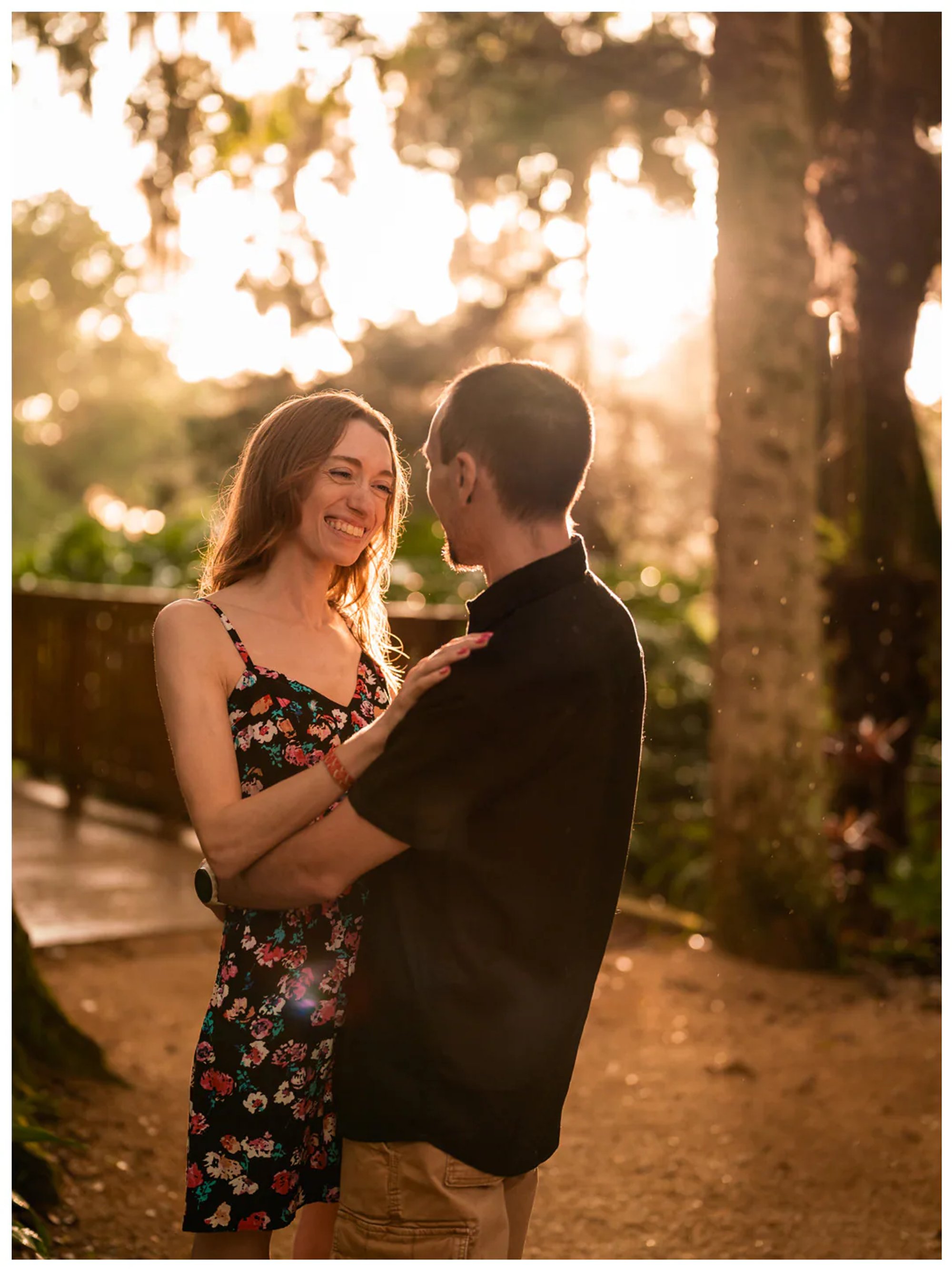 Couple smiling at each other in warm evening light during a Washington Oaks Gardens photo session.