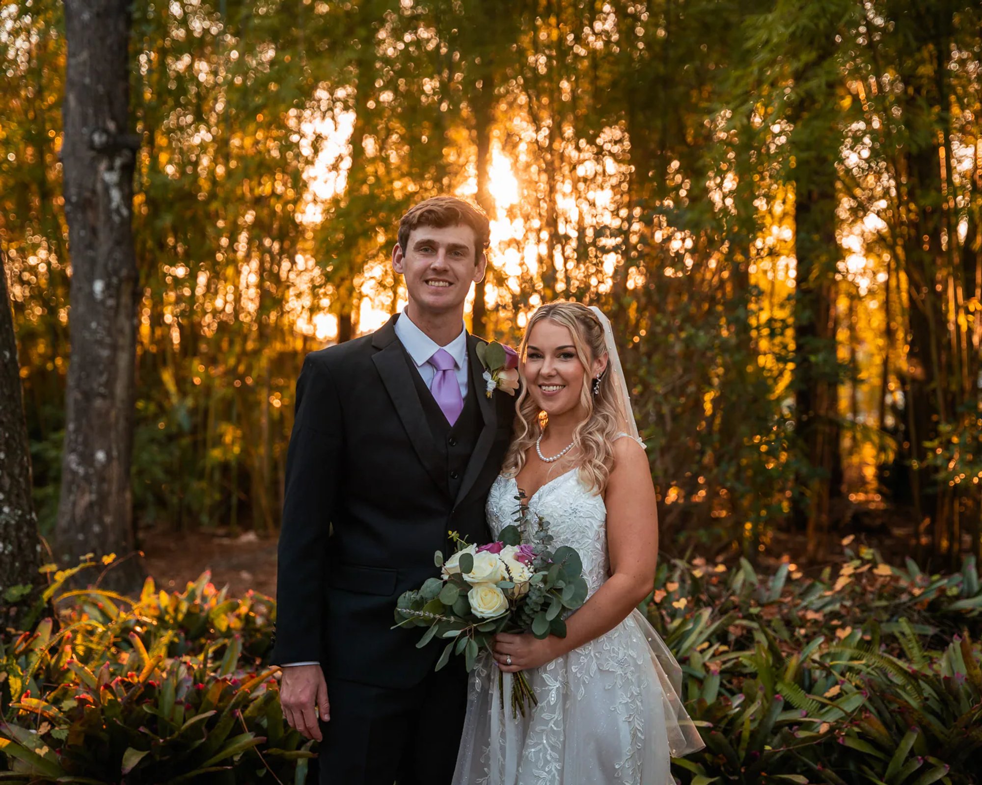 Bride and groom standing in wooded ceremony area at Bridle Oaks Barn in DeLand Florida