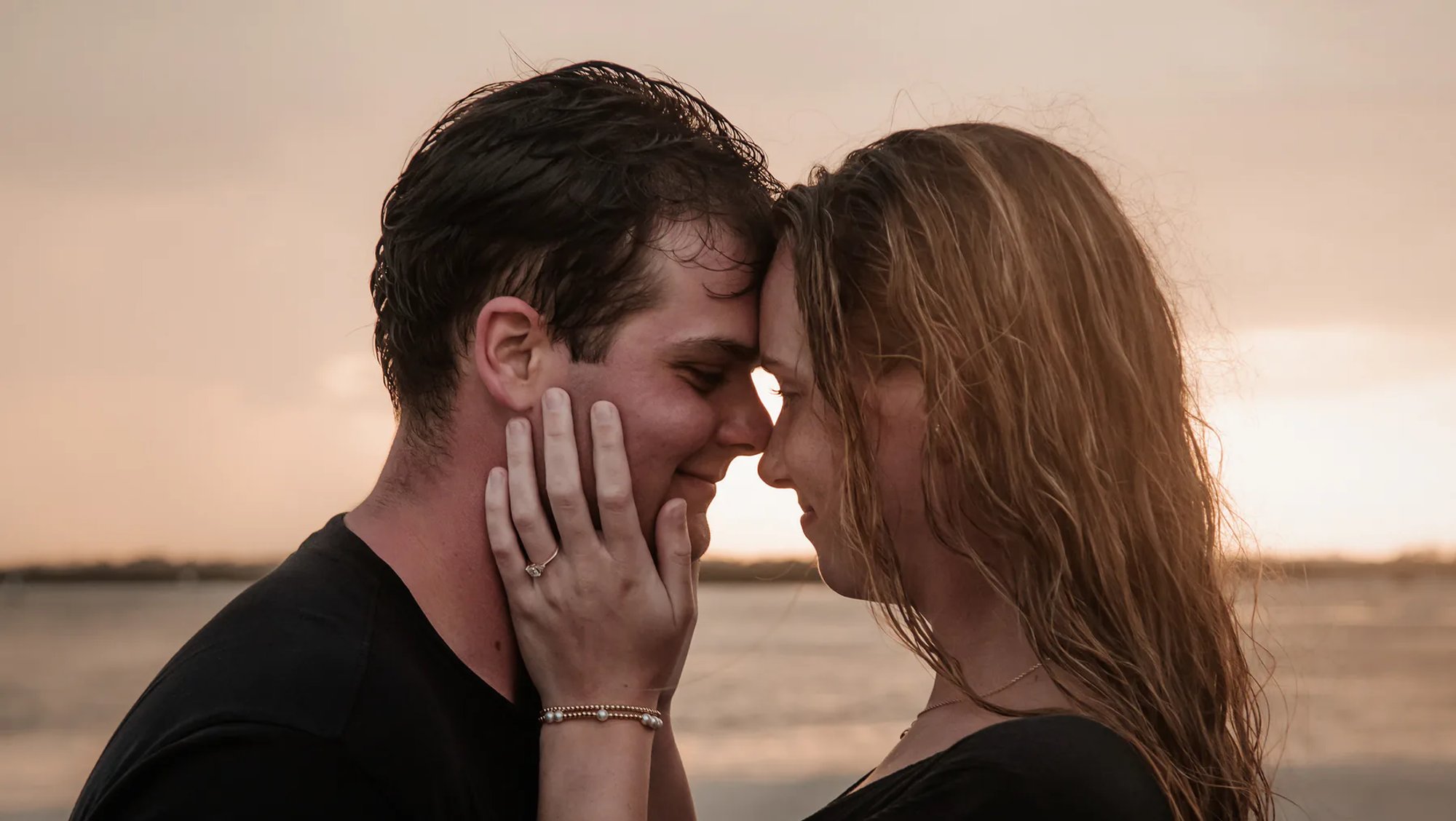 Close engagement portrait of a couple touching foreheads.