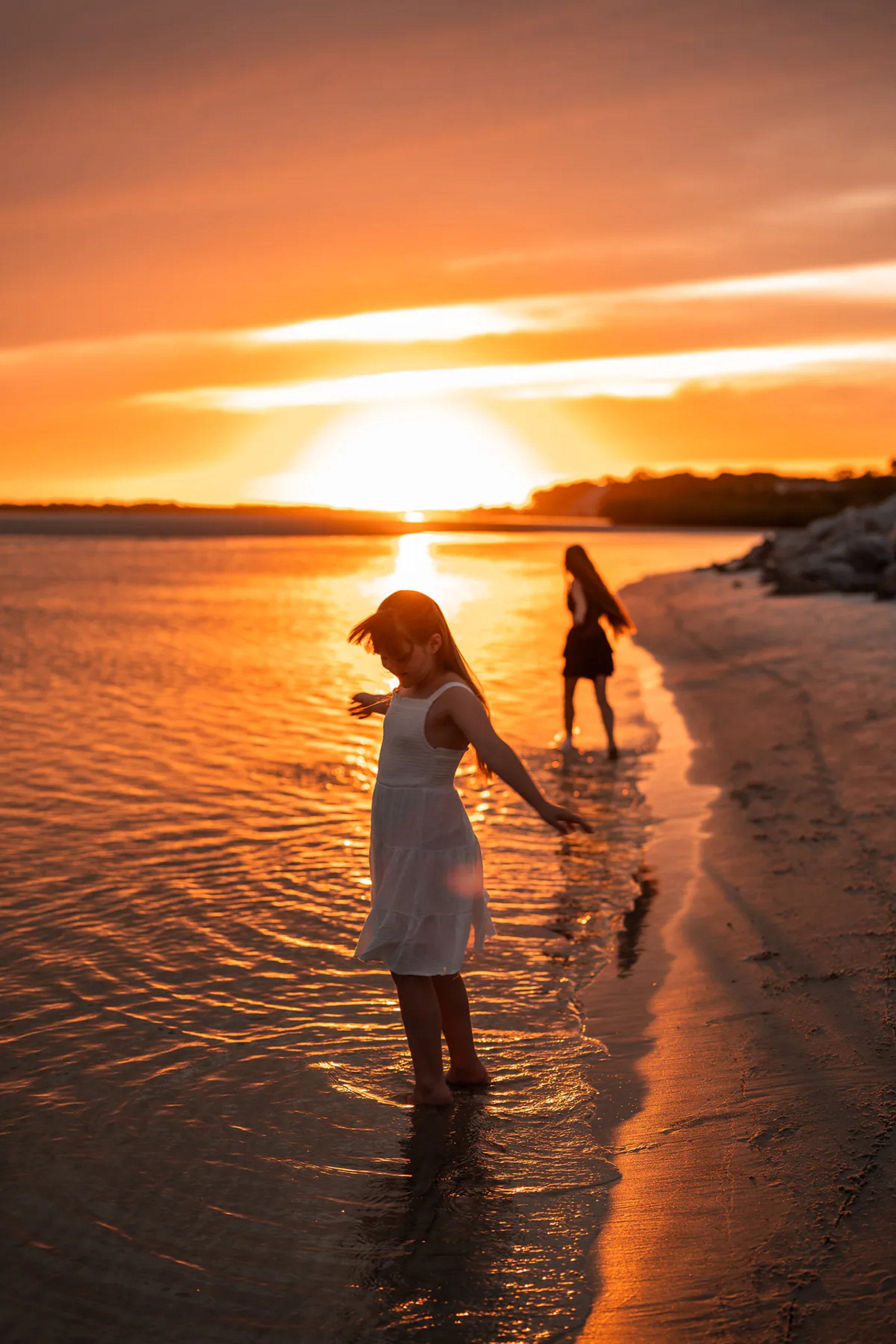 Girl standing by the shoreline during a sunset beach photography session in Ponce Inlet, Florida.