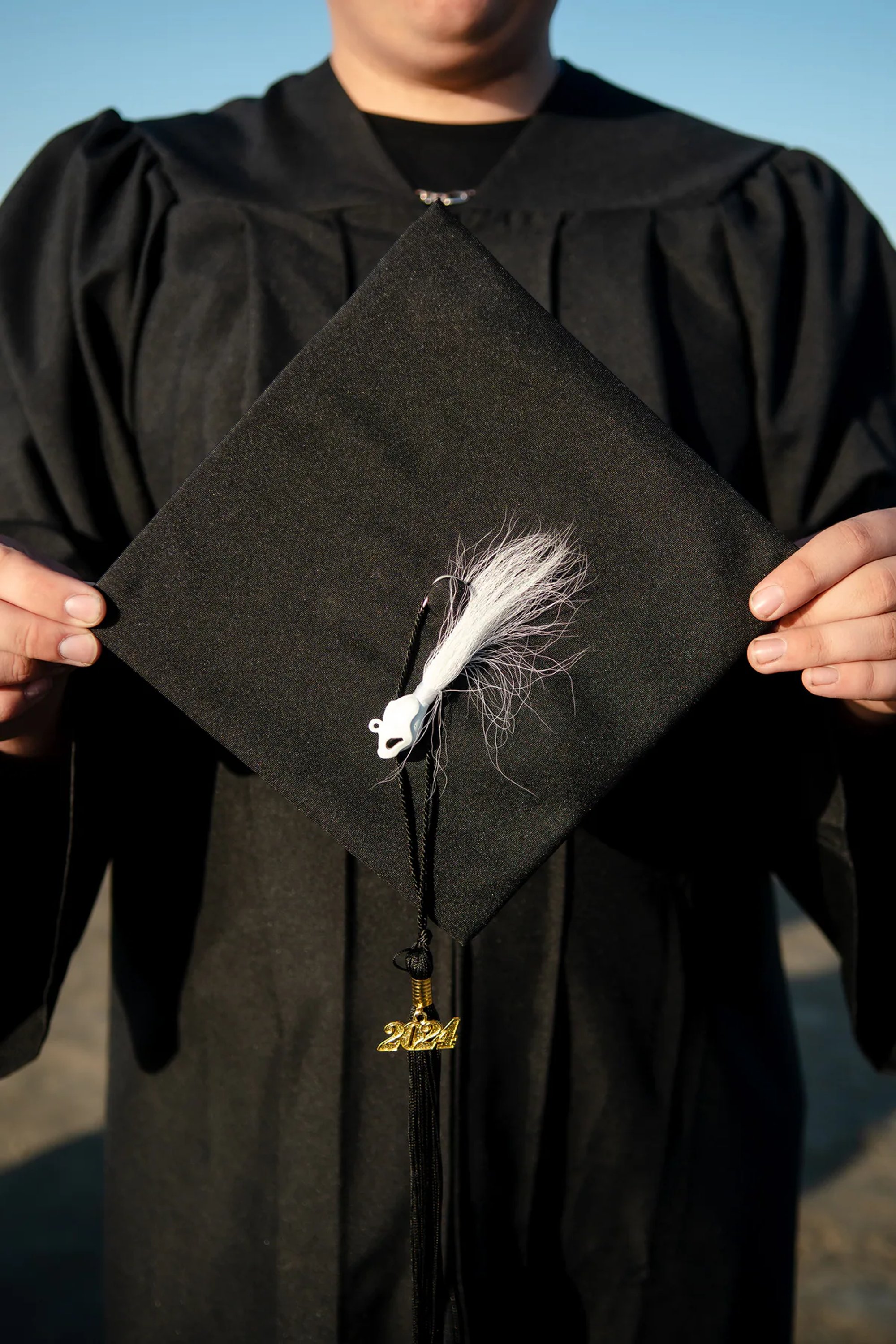 Graduate displaying a decorated black graduation cap.