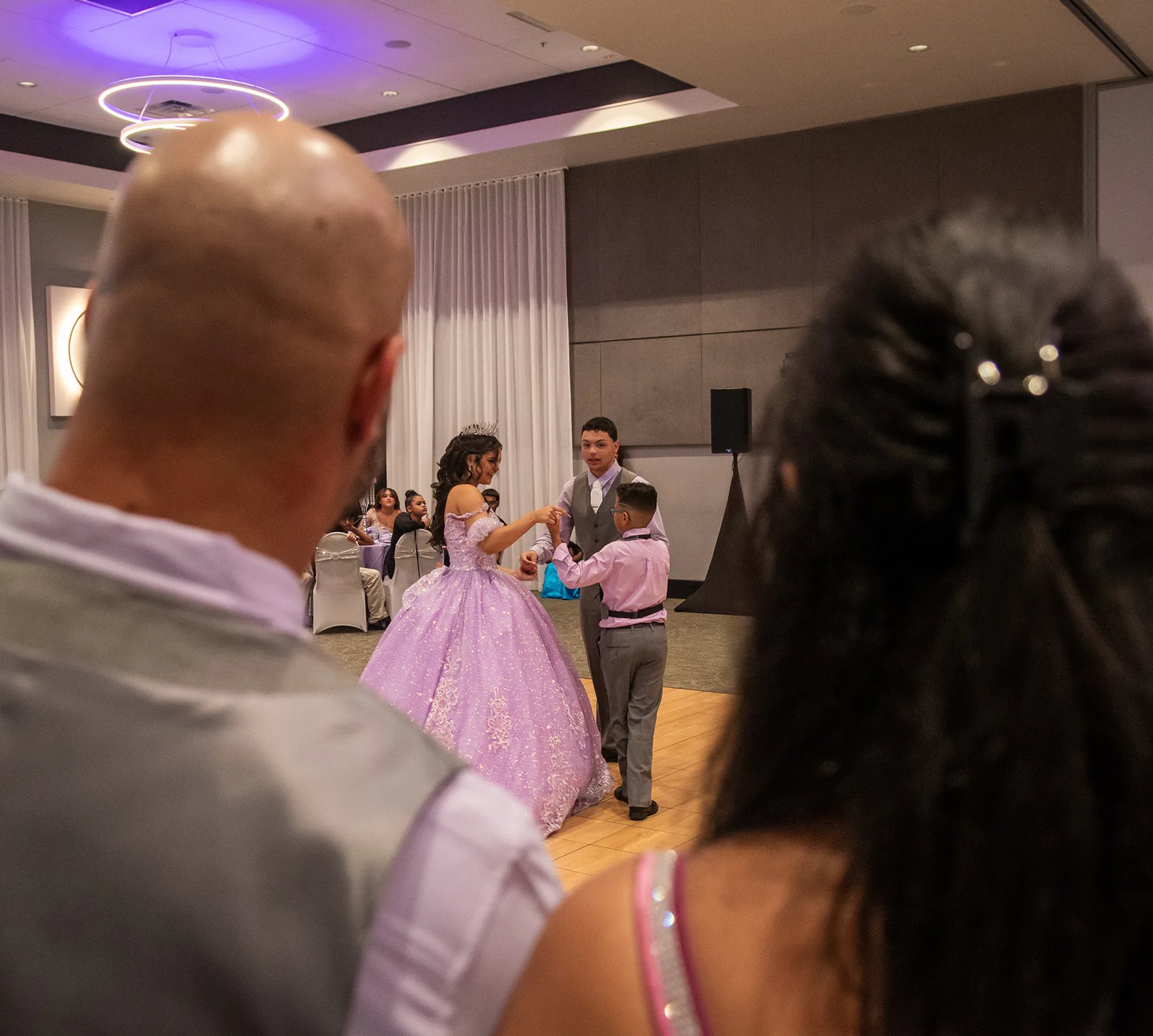 Quinceañera dancing with a guest during her reception.
