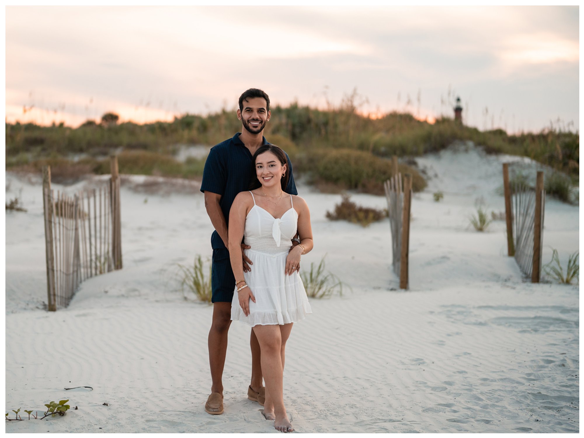 Dierick and Paulina smiling together among the dunes near the Ponce Inlet Lighthouse.