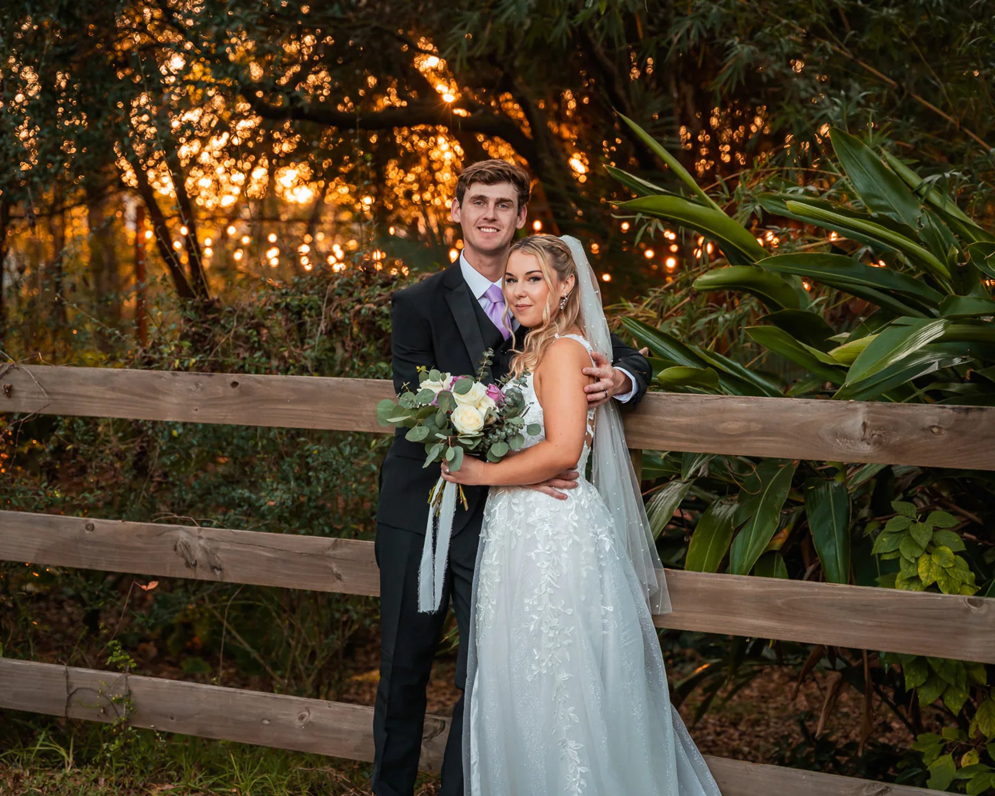 Bride and groom portrait by wooden fence during DeLand Florida barn wedding