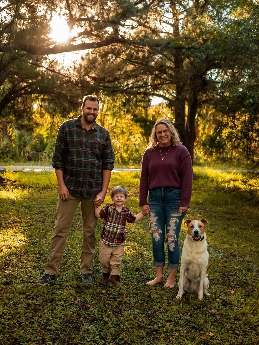 Family photos in the sunset with their dog and child