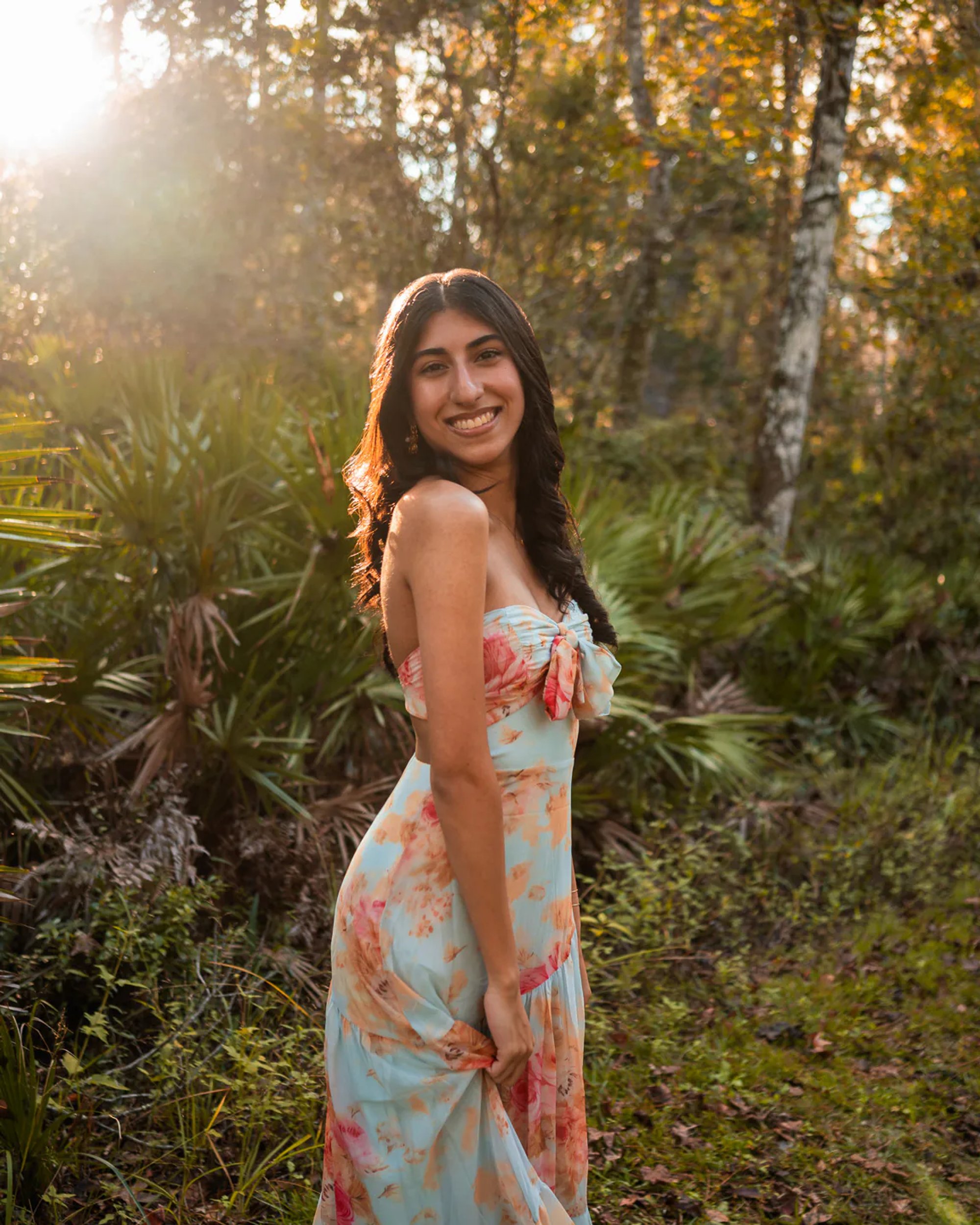 Ahaana in a floral dress on a wooded trail near Lake Woodruff