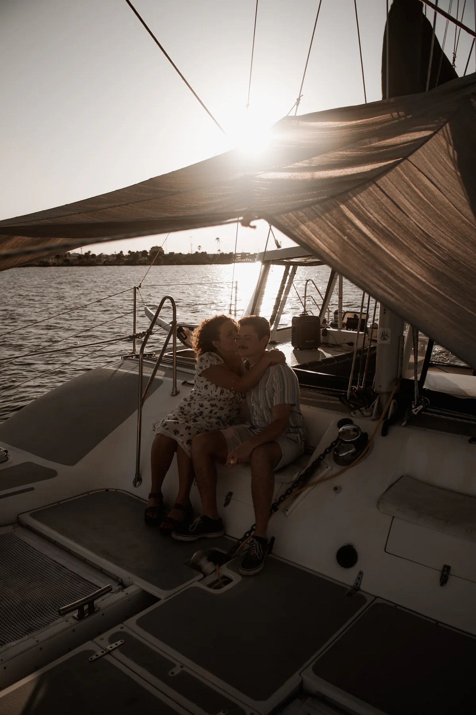 sailboat engagement photo of couple sitting together on a boat in Daytona Beach
