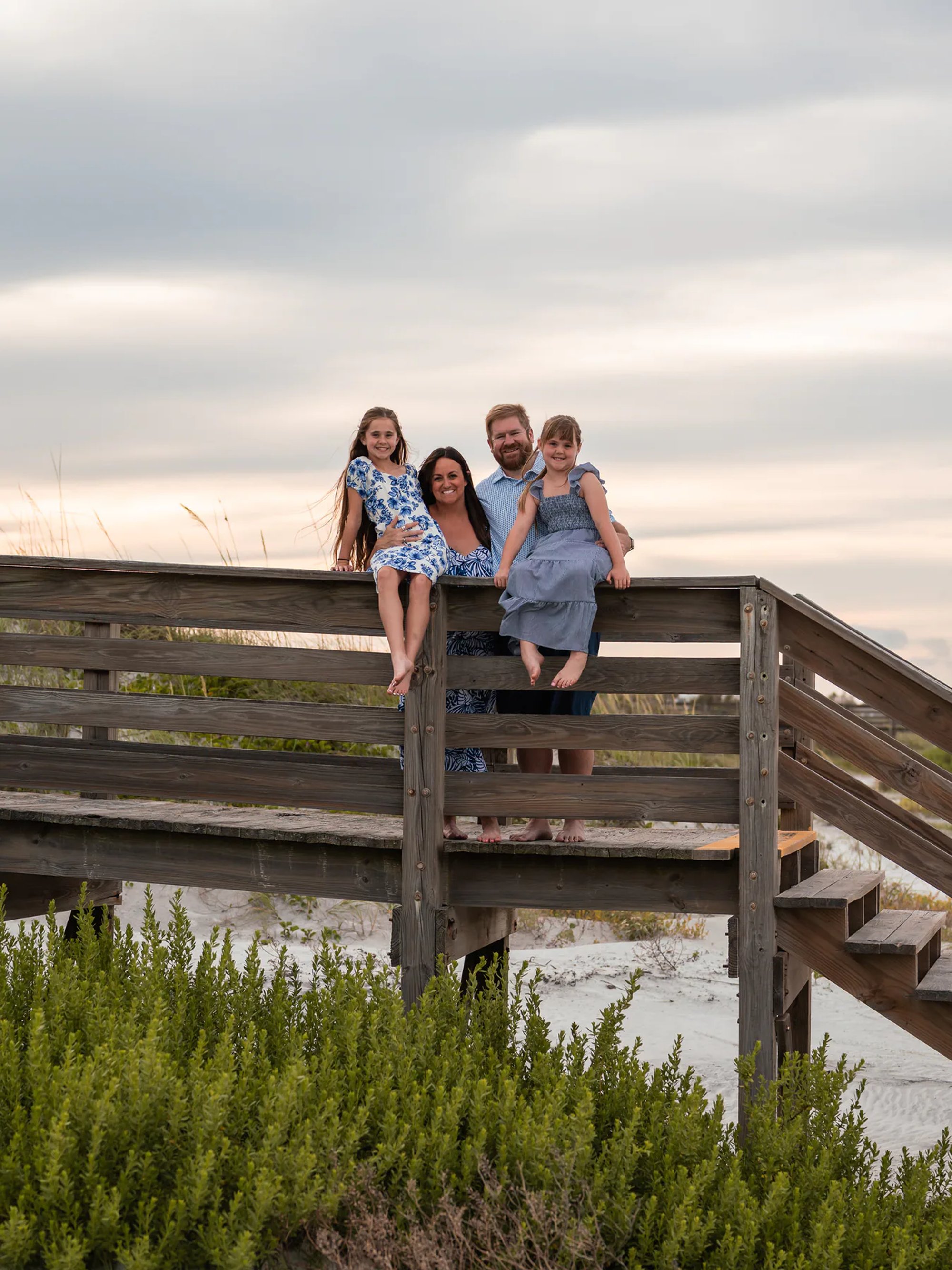 Family portrait on the boardwalk near the dunes during a Ponce Inlet Beach photography session.