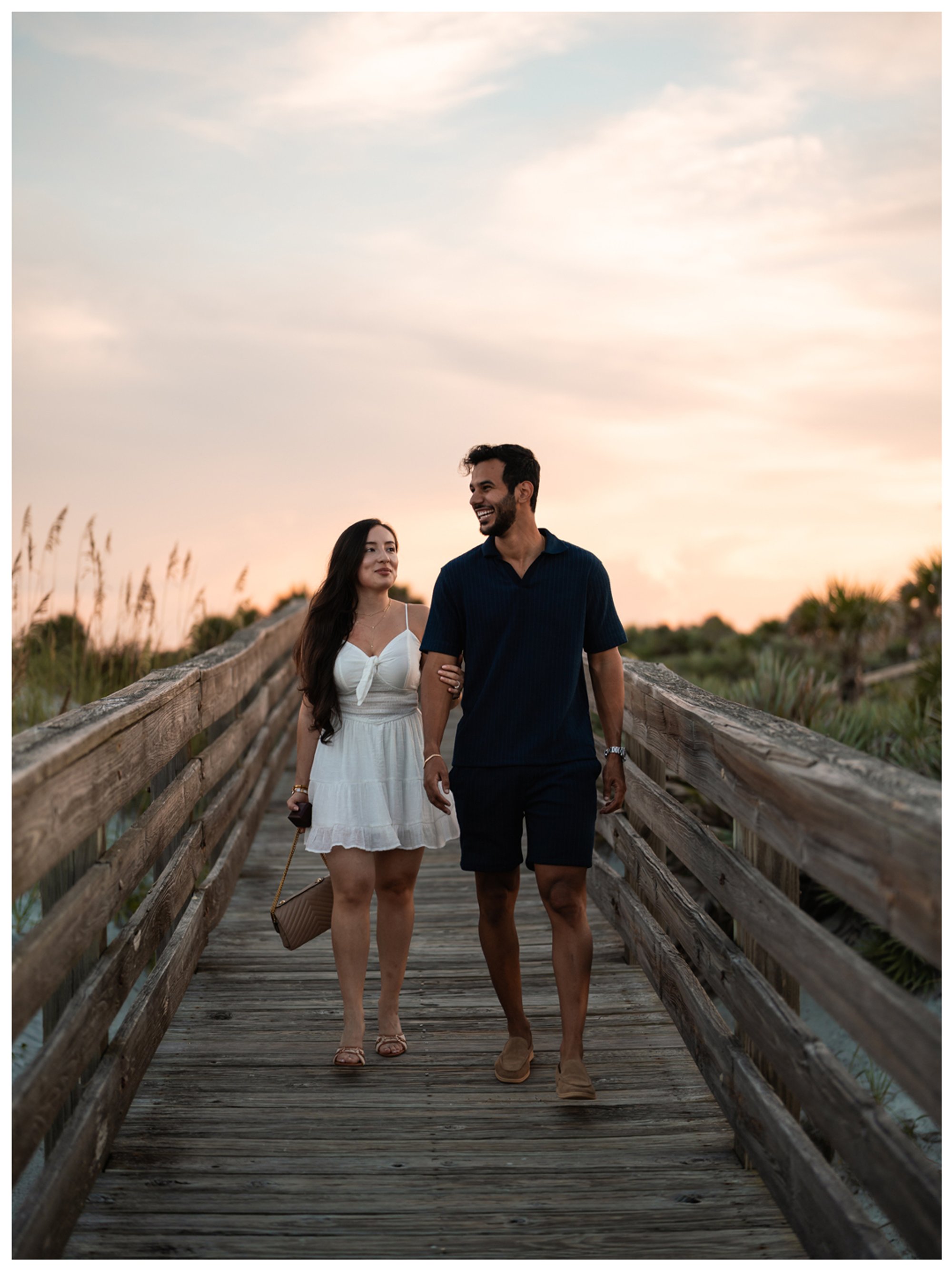 Dierick and Paulina walking along the Lighthouse Point Park boardwalk in the evening light.