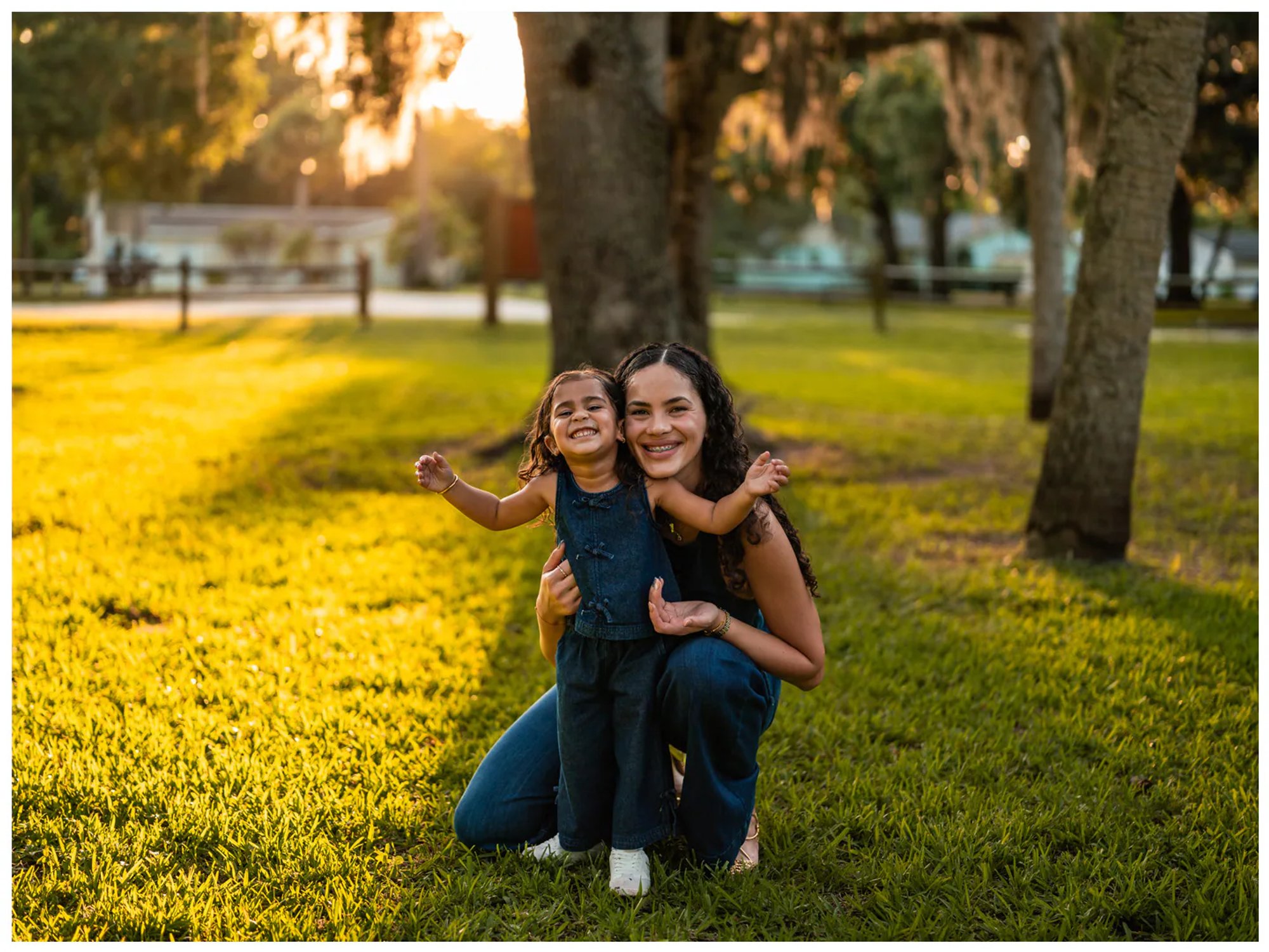 Mother and daughter sitting together under trees at Buschman Park in Port Orange