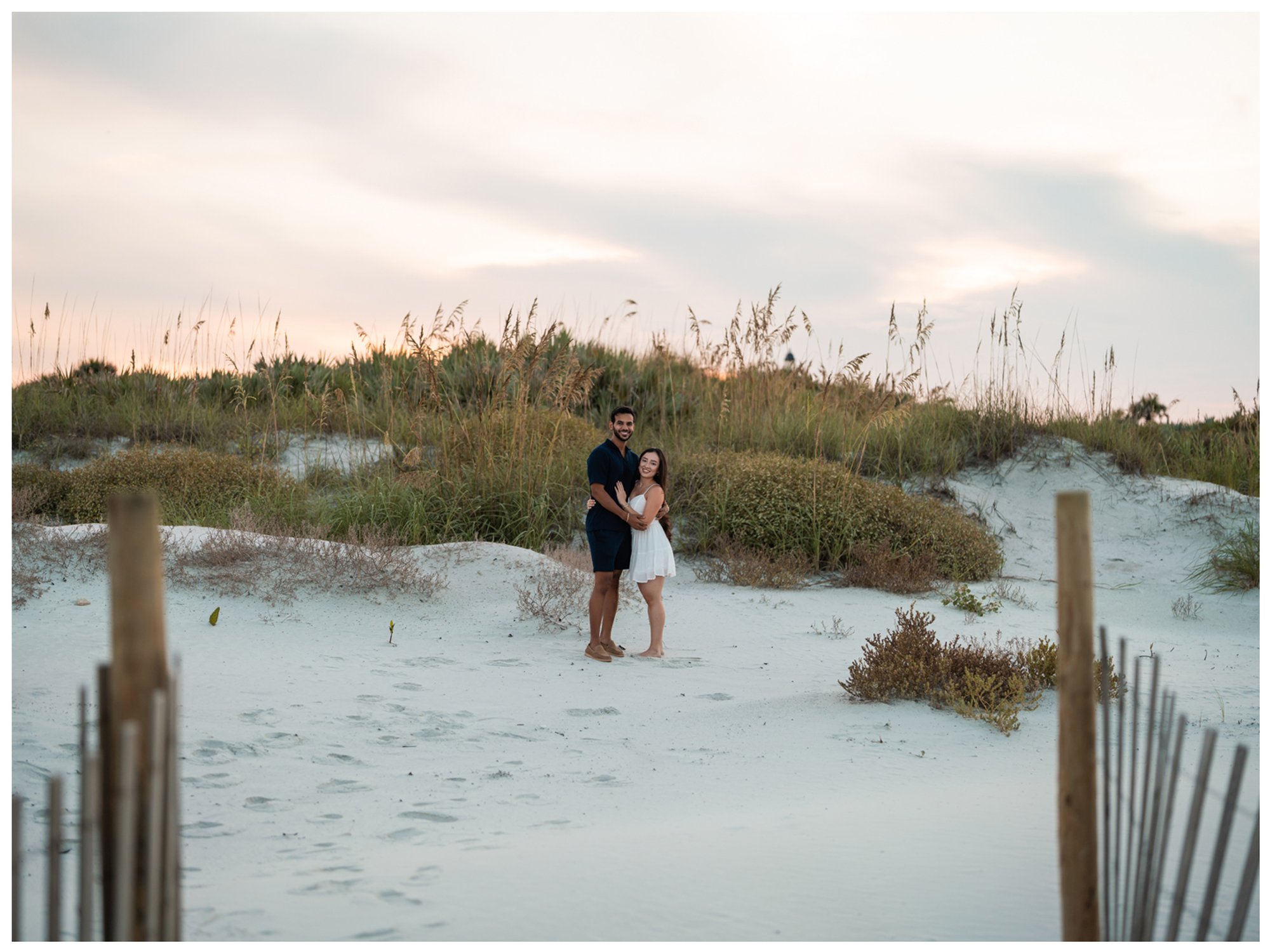 Wide evening portrait of Dierick and Paulina among the beach dunes at Lighthouse Point Park.