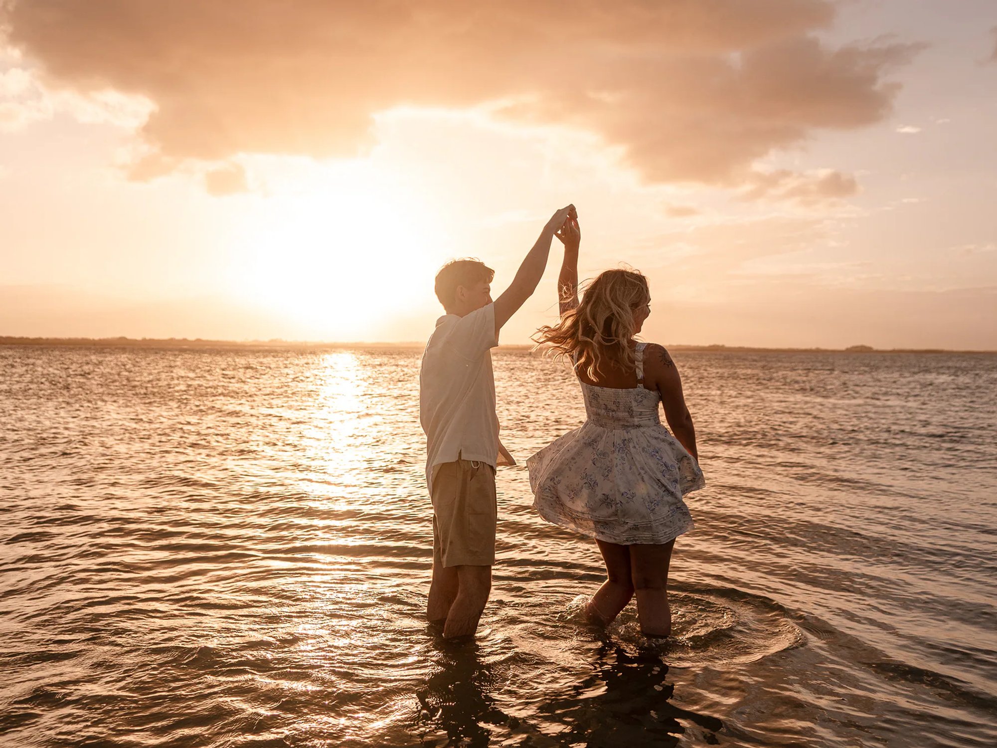 Couple Dancing and spinning in the water during a New Smyrna Beach engagement photo