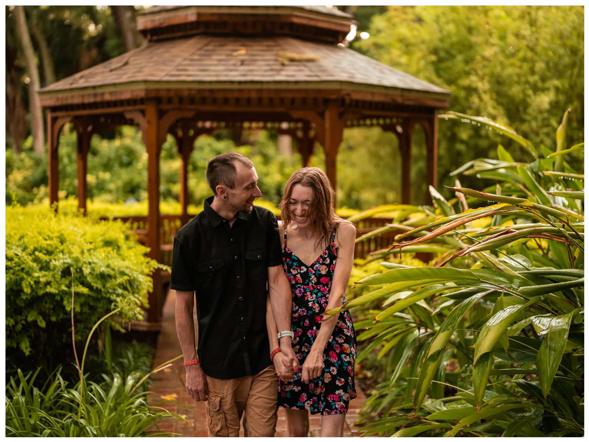 Couple walking hand in hand past the gazebo in the formal gardens at Washington Oaks State Park.