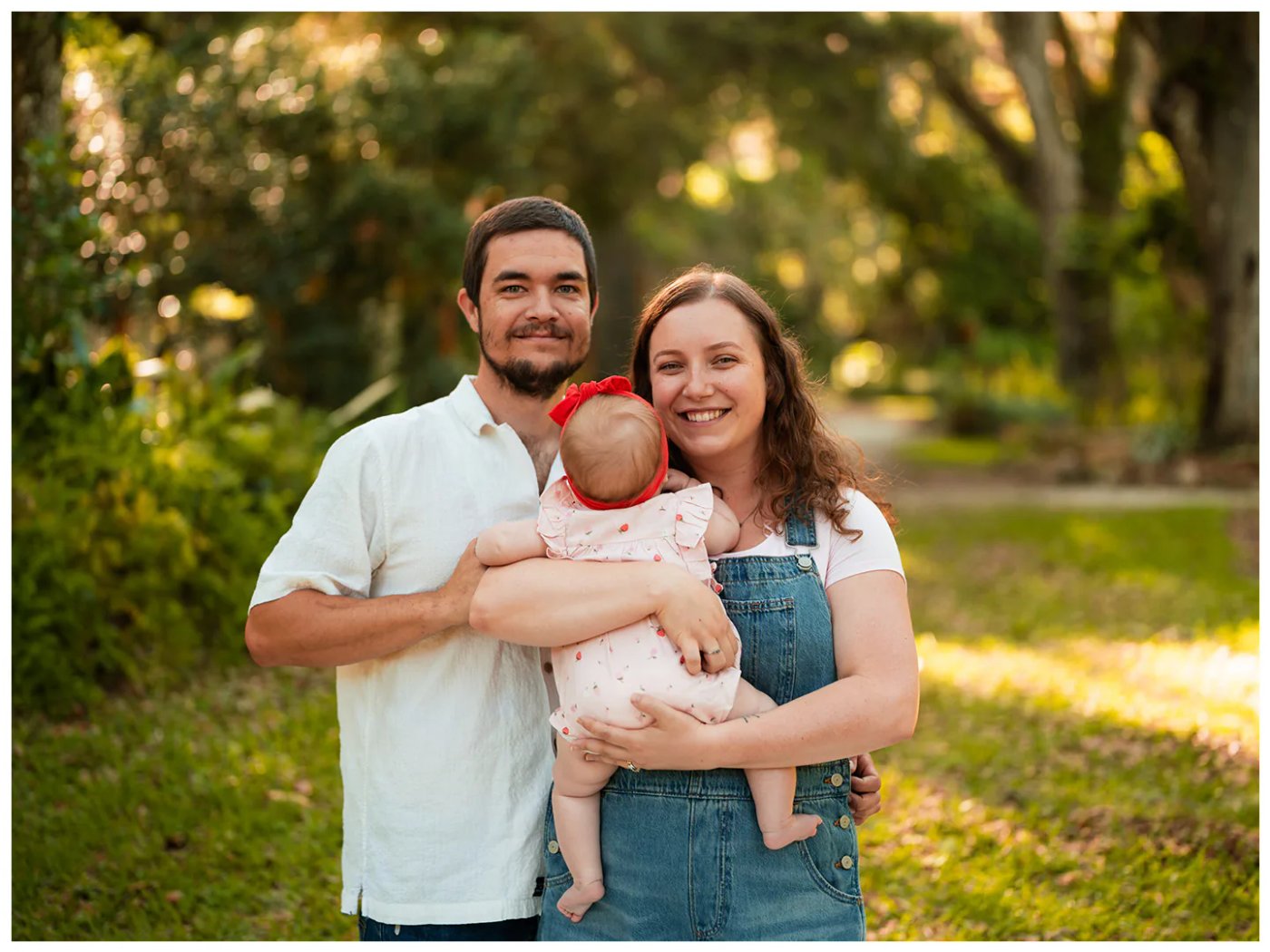 Port Orange family photos at Dunlawton Sugar Mill Gardens with parents holding baby in warm garden light