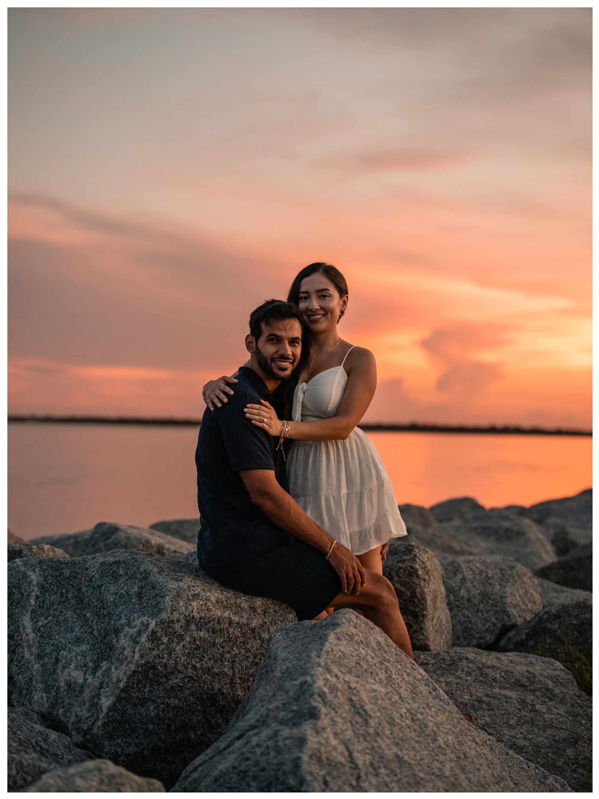 Dierick and Paulina smiling together beside the water at sunset in Ponce Inlet.
