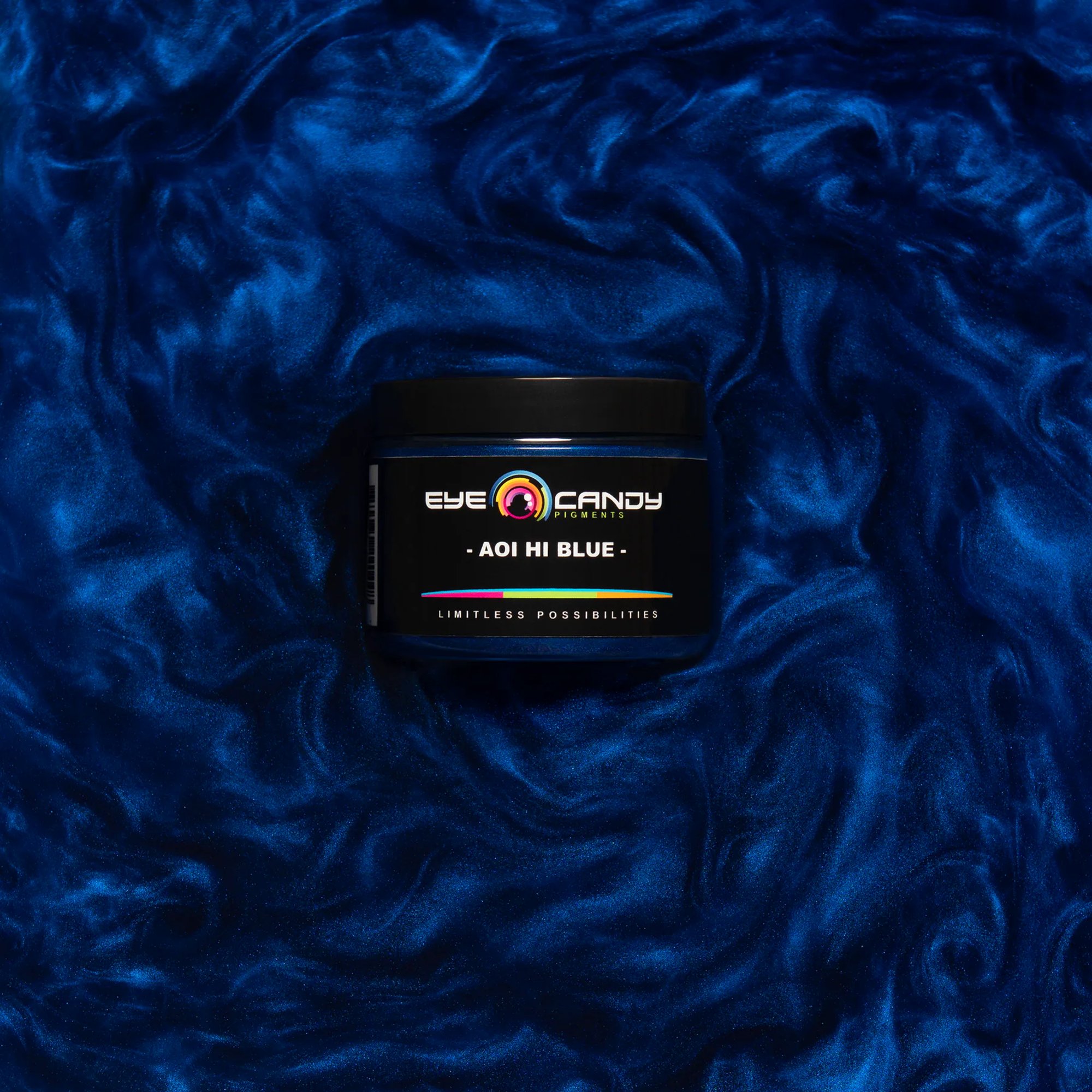 Eye Candy Pigments Aoi Hi Blue jar on textured blue fabric.