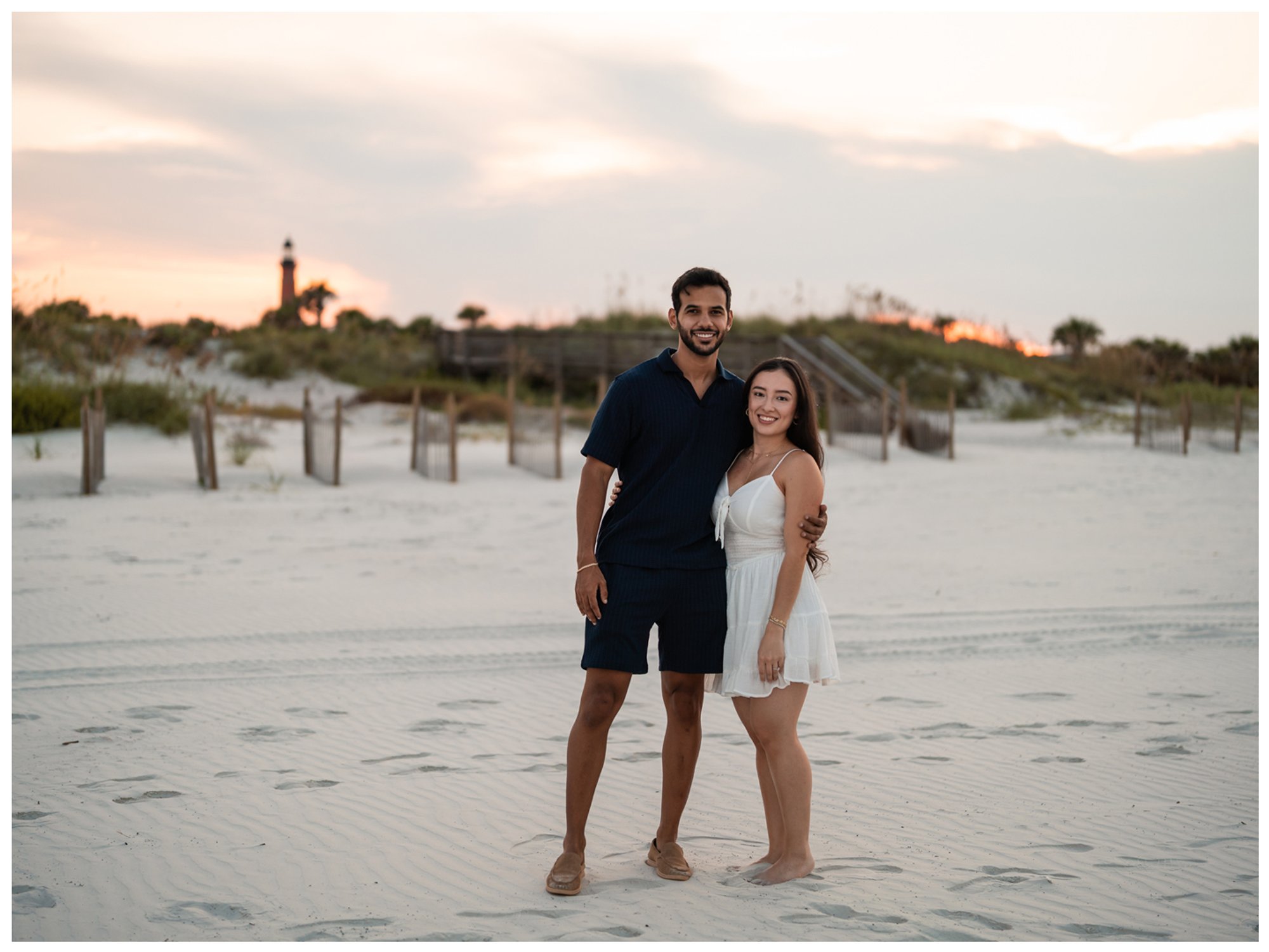 Dierick and Paulina standing on the Ponce Inlet beach with the lighthouse in the background.