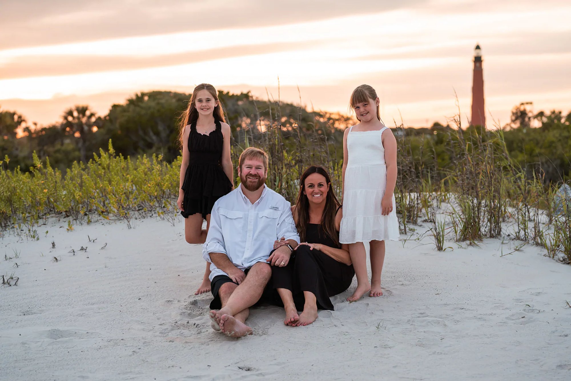 Family portrait in the dunes with the Ponce Inlet Lighthouse in the background.