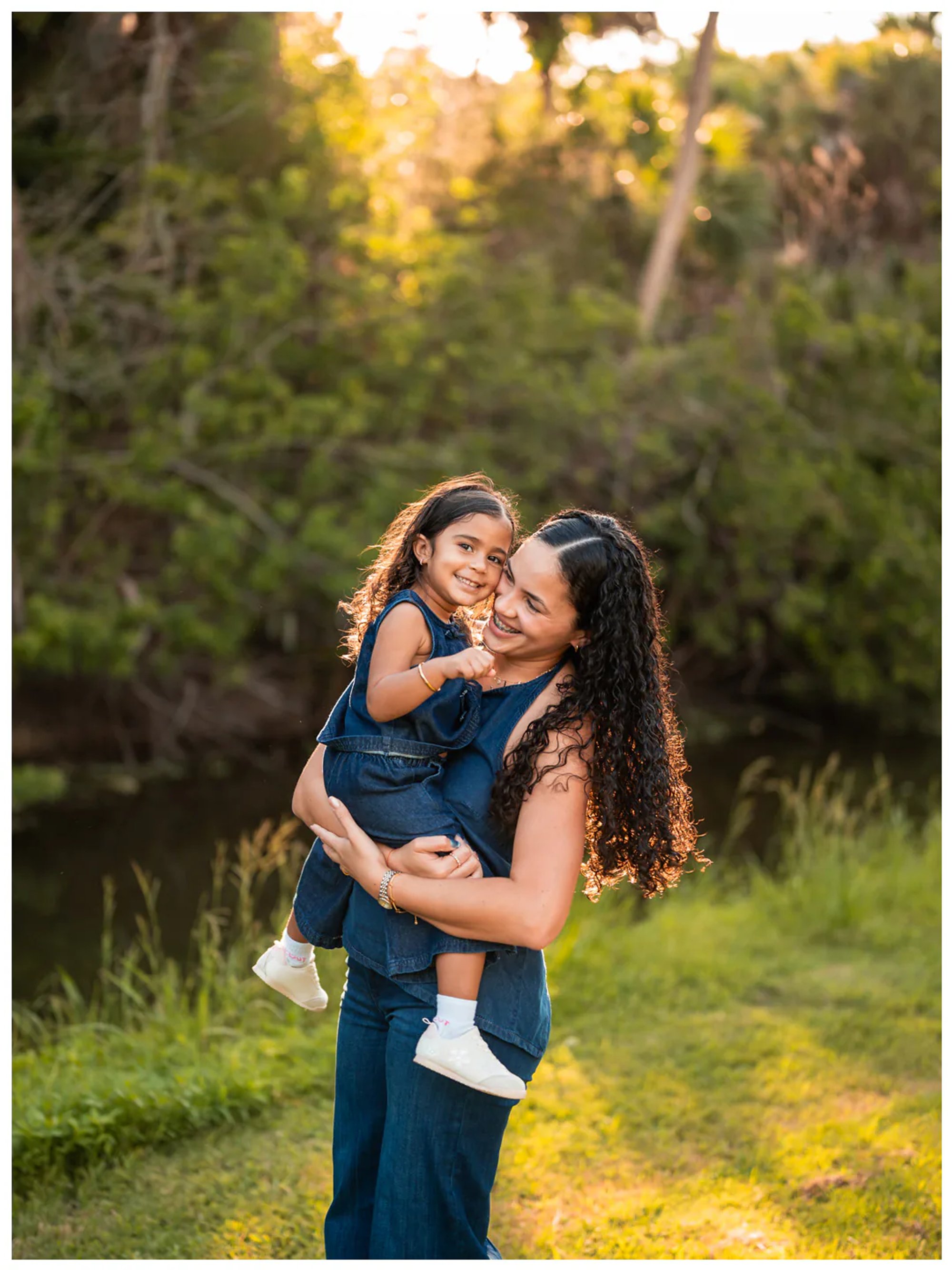 Mother holding daughter near the water during Buschman Park family photos