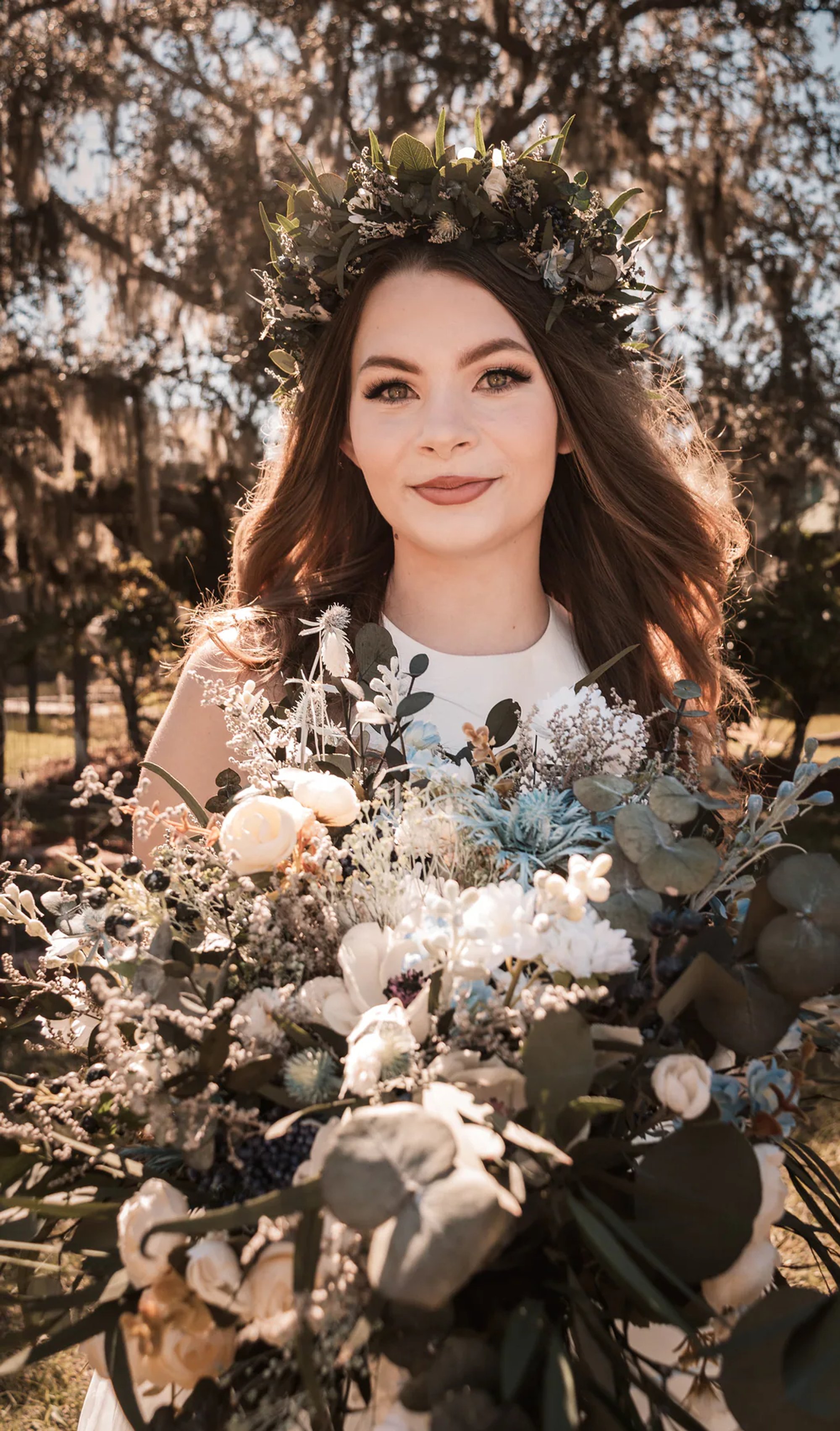 Bride holding her bouquet during a sunlit outdoor portrait.