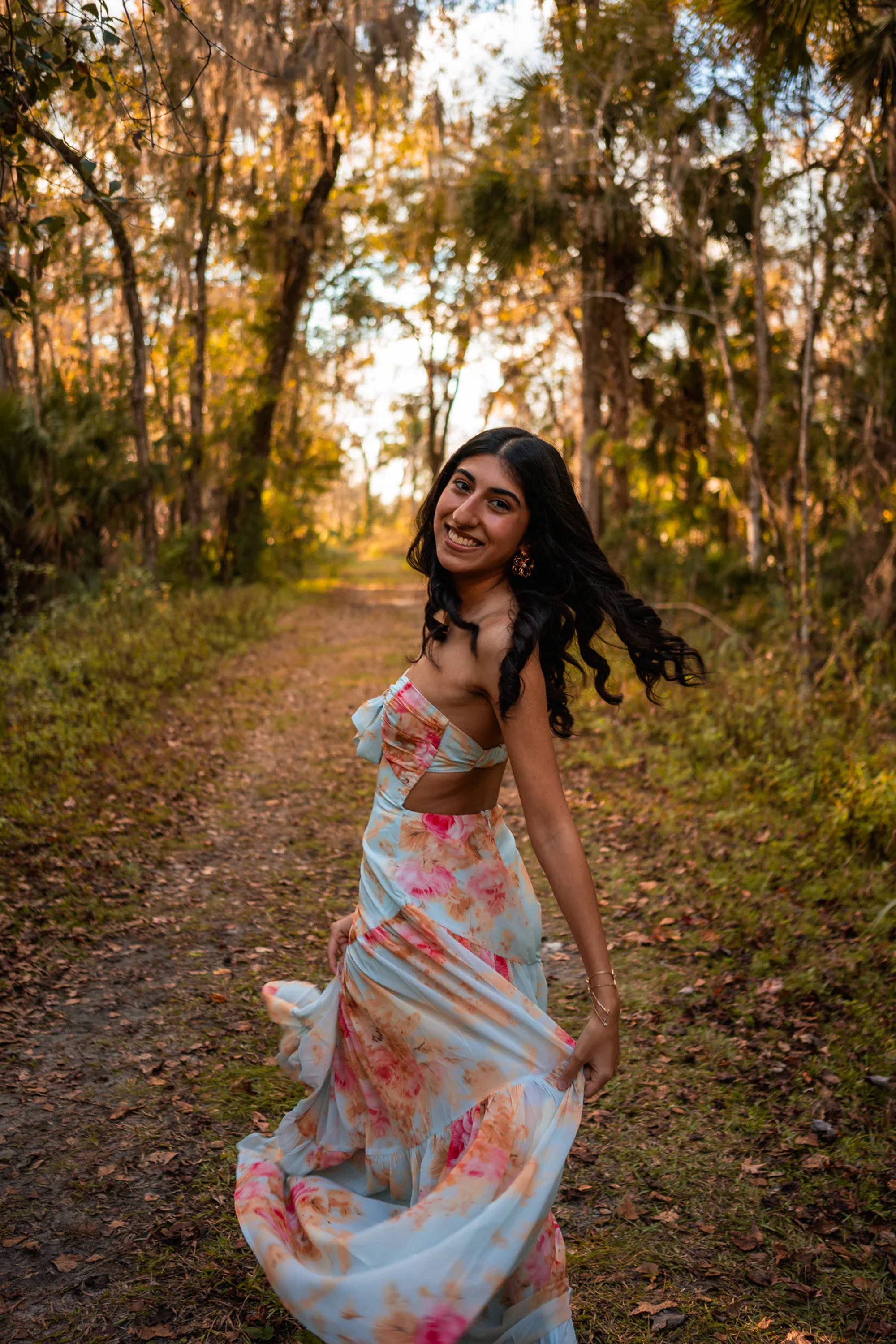 Ahaana smiling on a natural trail for senior photos near DeLeon Springs