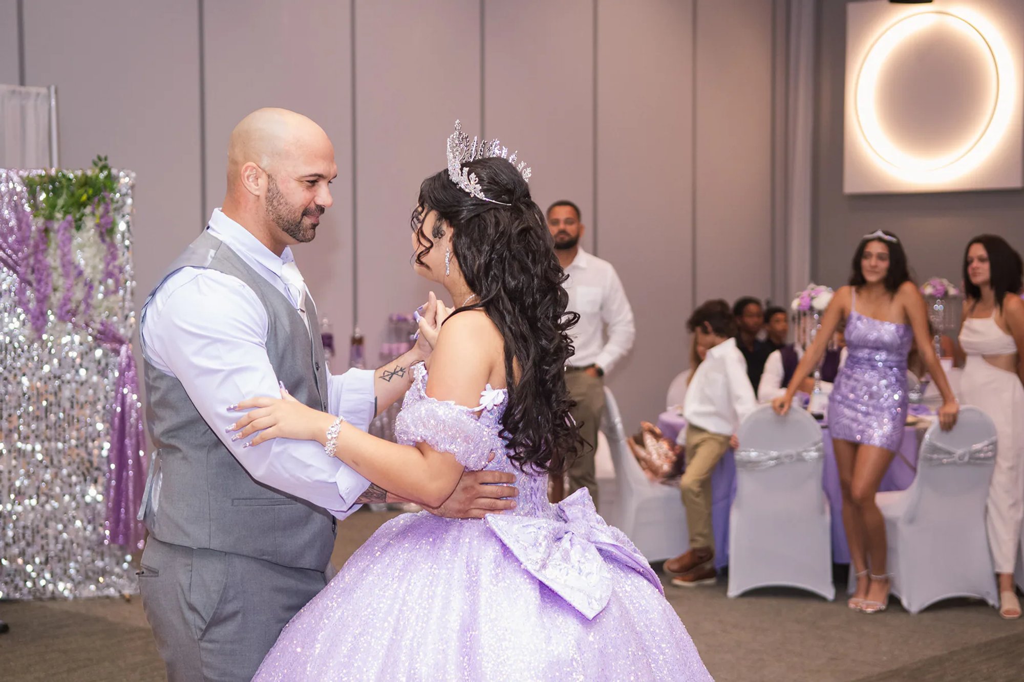 Quinceañera dancing with a guest during her reception.