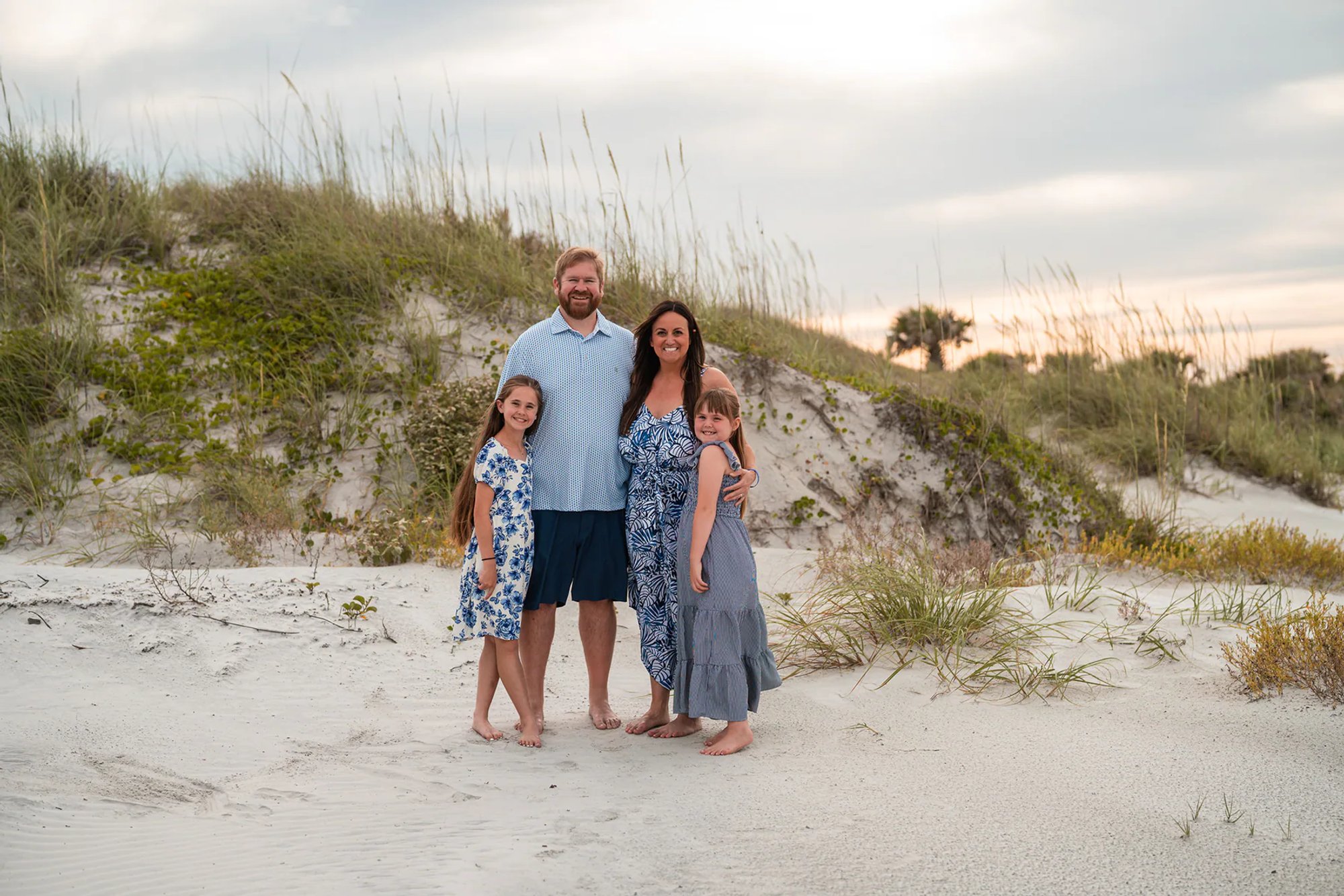 Family standing together in the beach dunes during a Ponce Inlet family photo session.