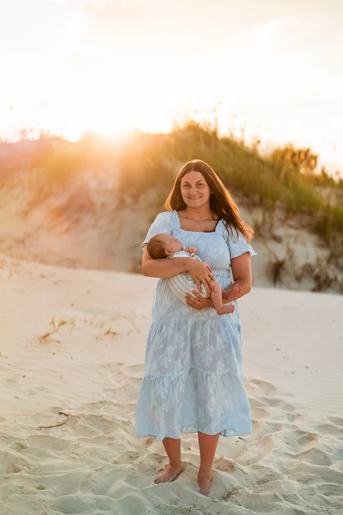 Mother holding her baby during a Ponce Inlet Jetty Beach family photography session.