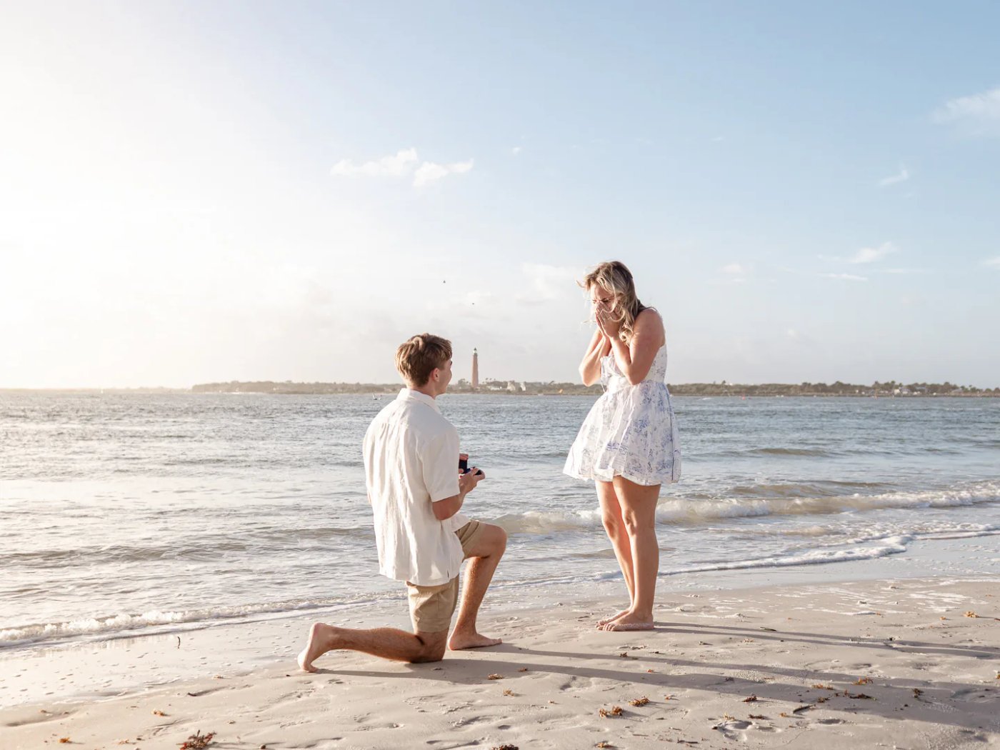 Man proposing on one knee to his partner at the beach.