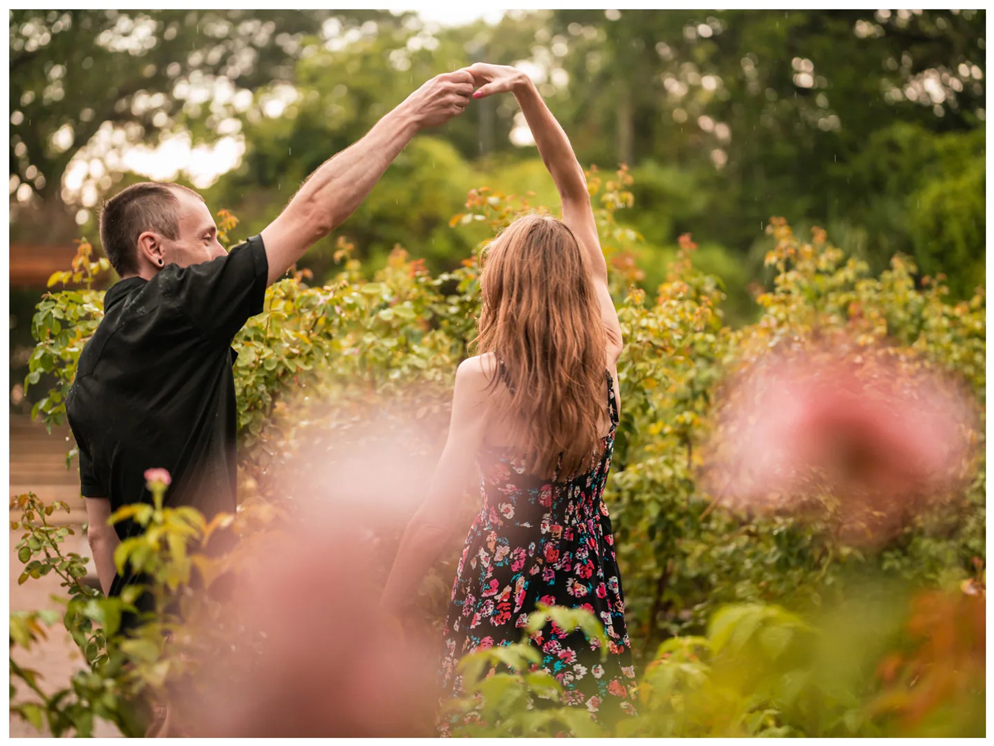 Man twirling his partner between flowering plants at Washington Oaks Gardens State Park.