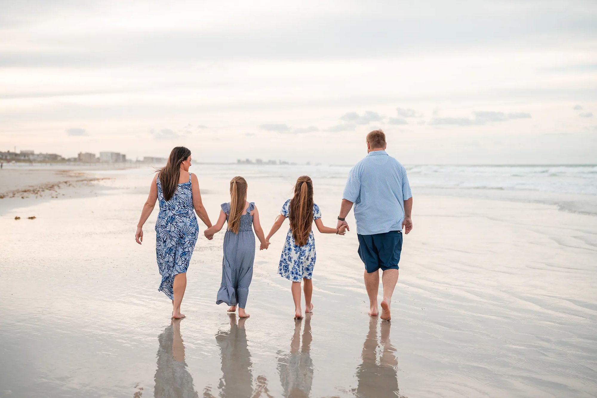 Family walking along the shoreline during a Ponce Inlet Beach family photography session.