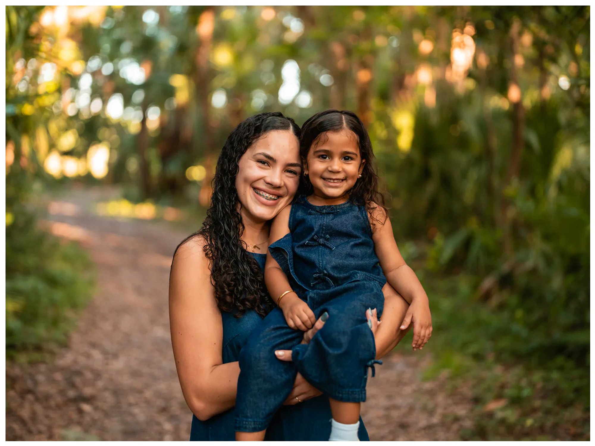 Mother holding daughter during family photos on trail at Buschman Park