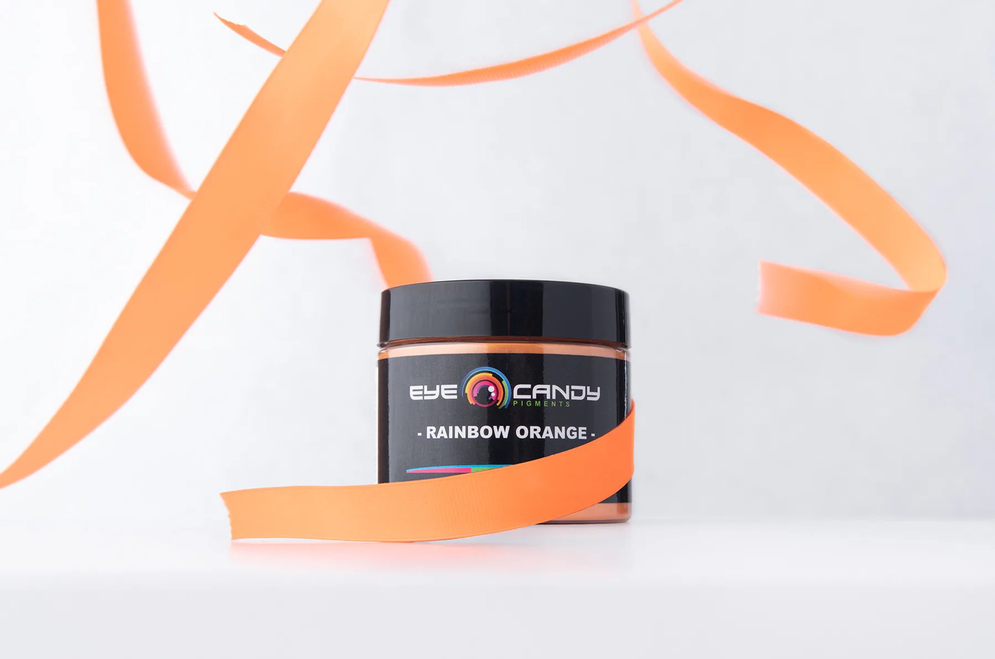 Eye Candy Pigments Rainbow Orange jar with flowing orange ribbon.