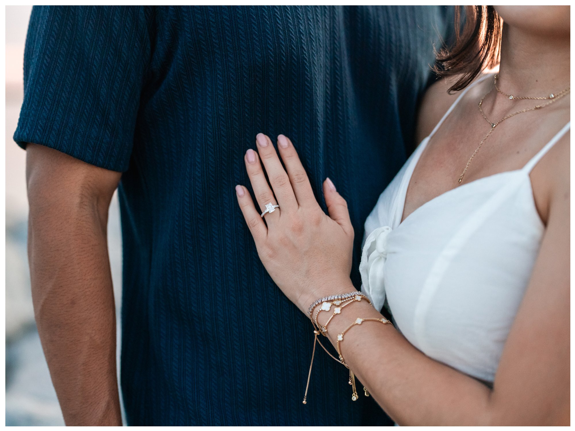 Close-up of Paulina’s engagement ring resting against Dierick’s navy shirt.