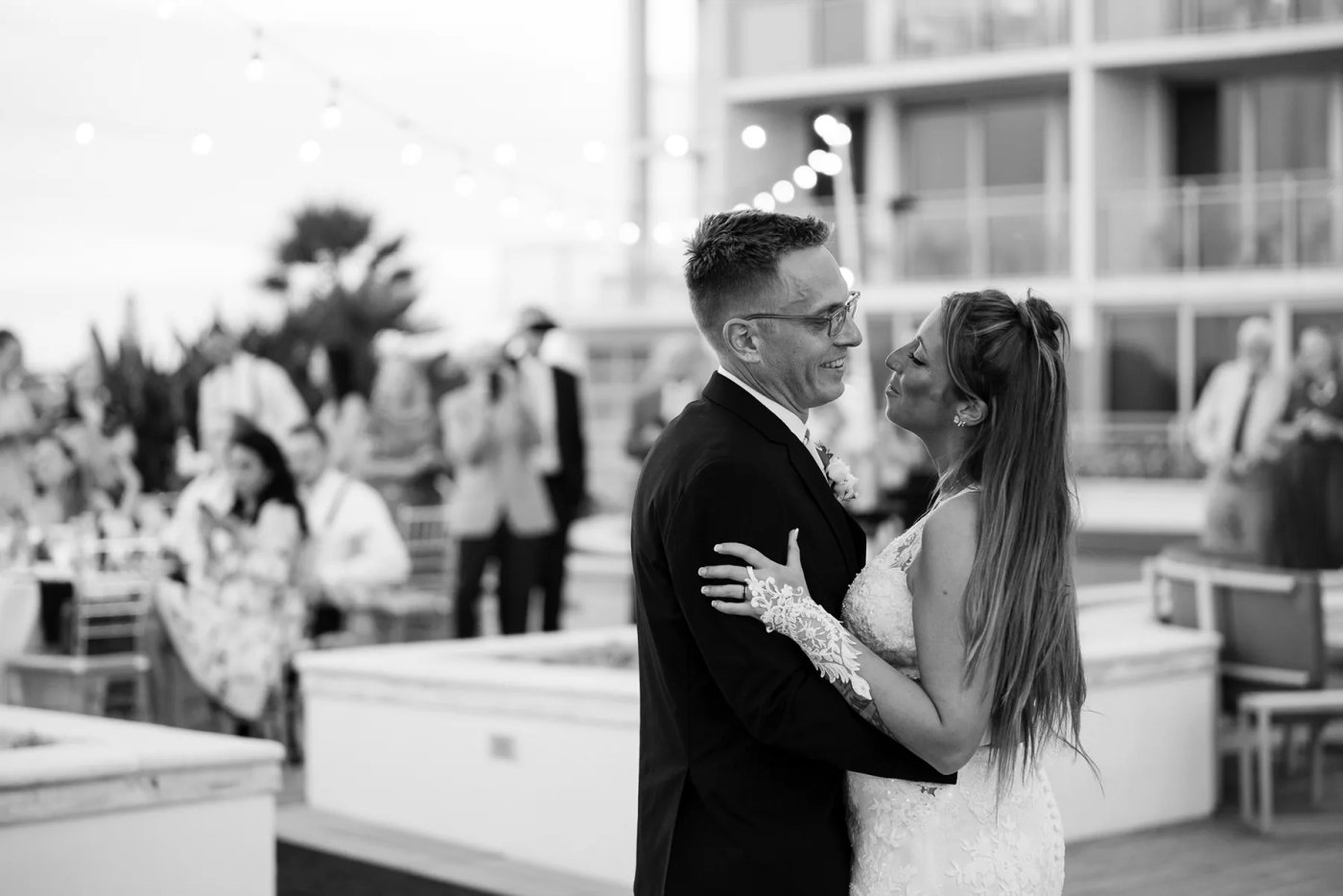 Newlyweds dancing together in a black-and-white reception photograph.