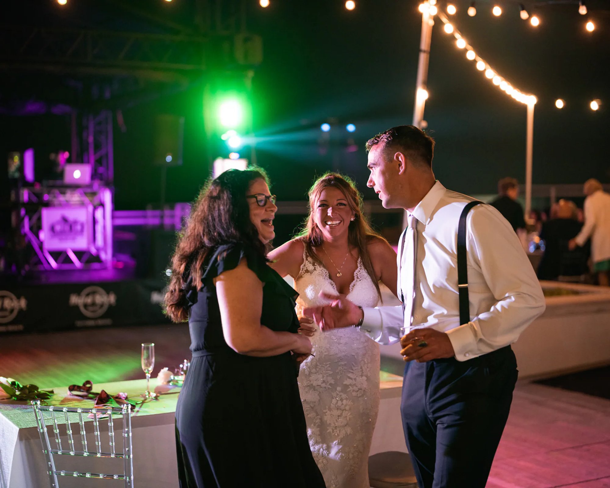 Bride and groom laughing with guests during their Hard Rock Hotel Daytona Beach wedding reception.