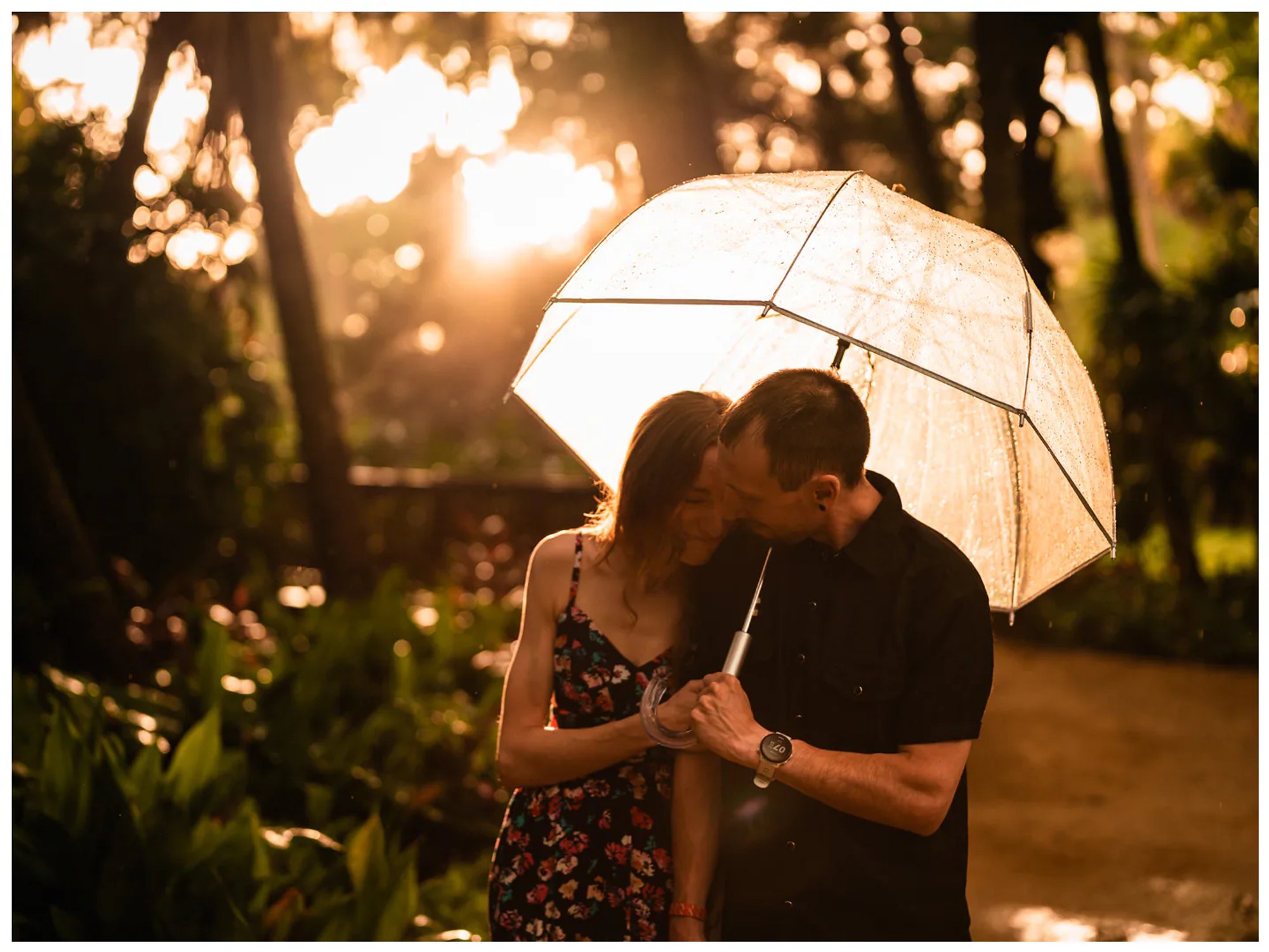 Couple sharing a quiet moment beneath a backlit umbrella at Washington Oaks Gardens.