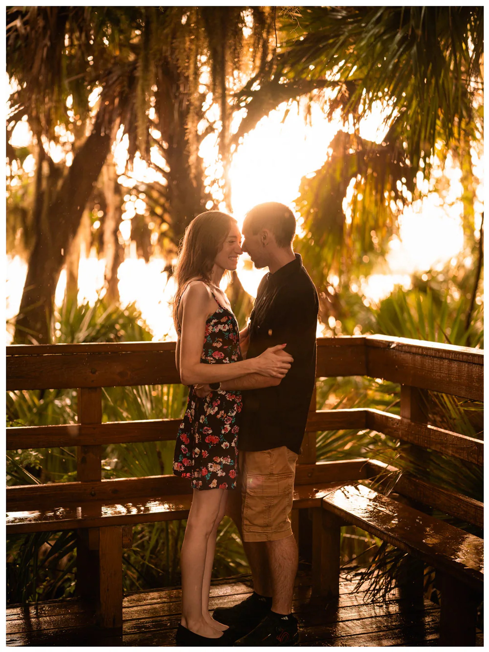 Couple kissing on a wet wooden footbridge at sunset at Washington Oaks Gardens State Park.