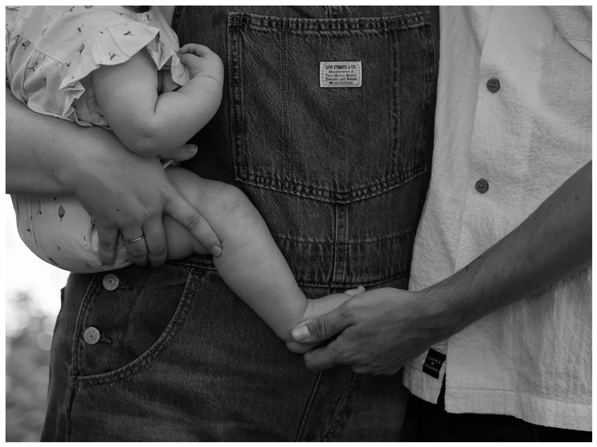 Black and white family photo detail of parents holding baby at Dunlawton Sugar Mill Gardens in Port Orange Florida