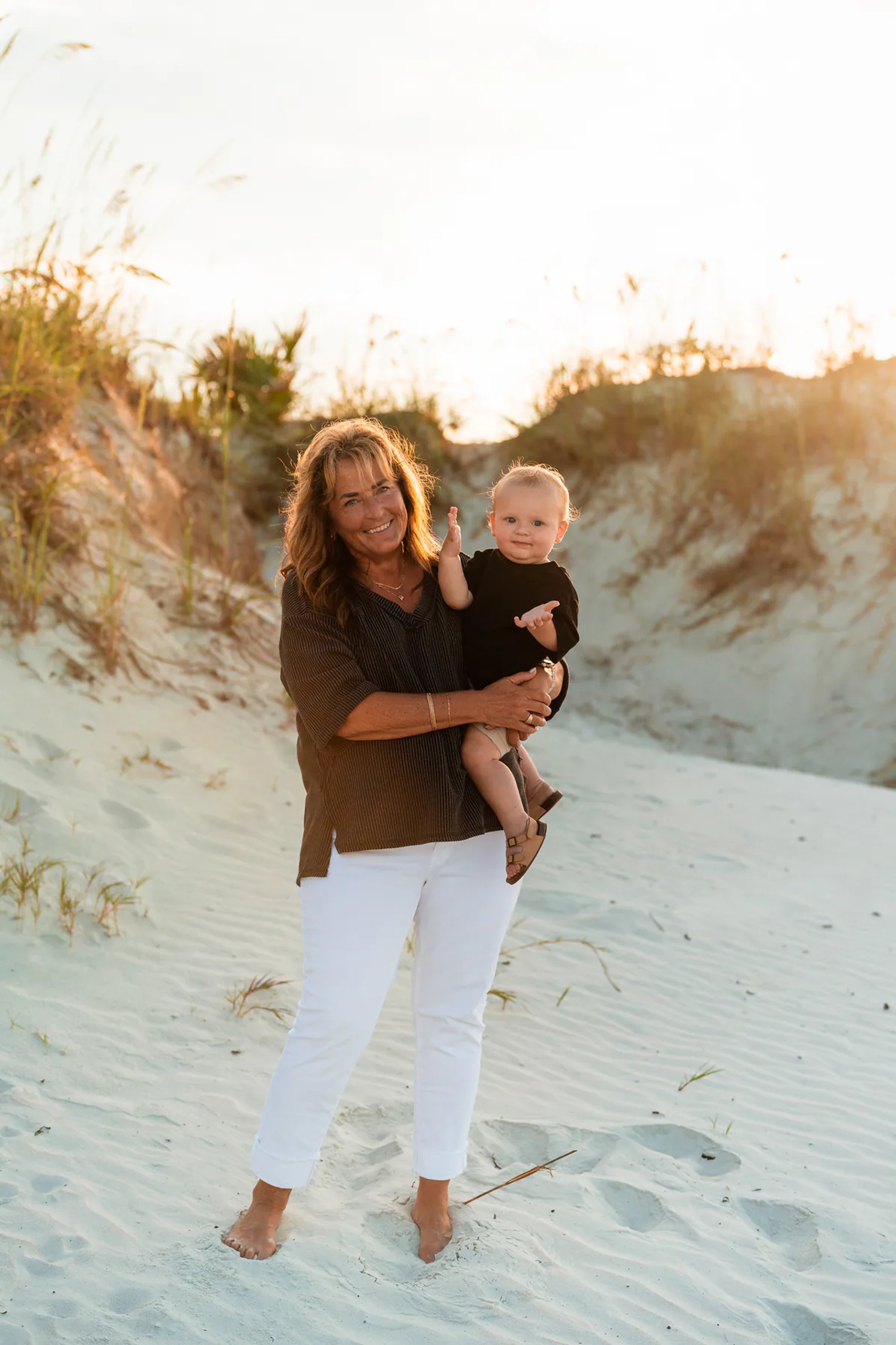Woman smiling while holding a child during a Ponce Inlet Jetty Beach family photography session.