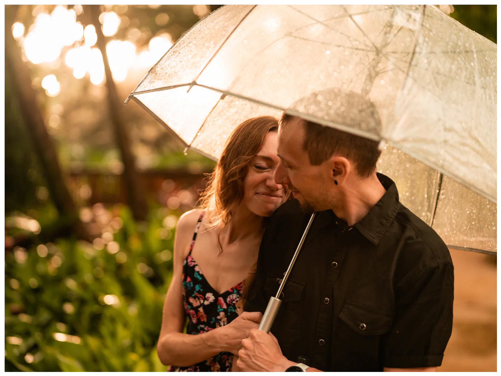 Couple laughing together in a close portrait beneath an umbrella at Washington Oaks Gardens State Park.